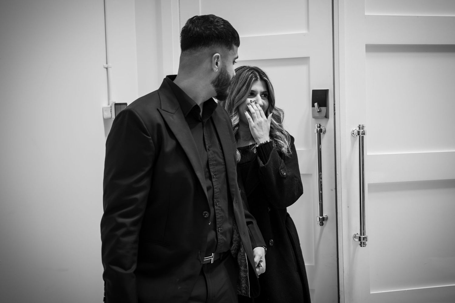 Black and white hallway shot showing elegant formal attire.