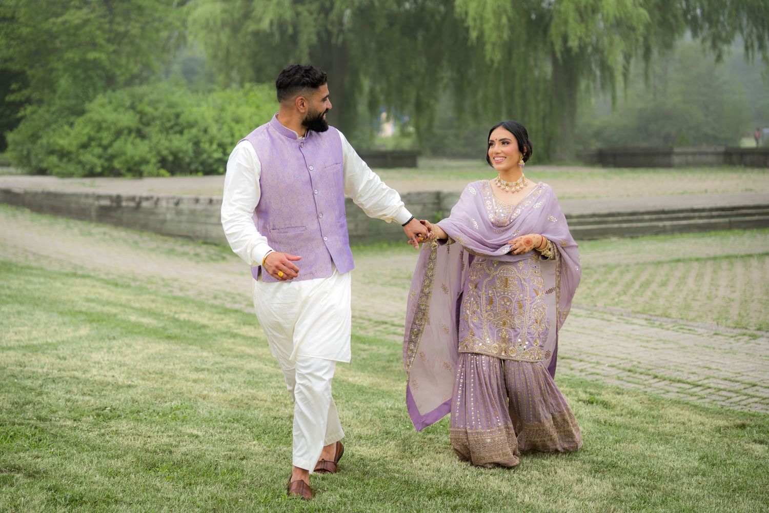 Romantic outdoor photoshoot sequence on grassy slope with couple in coordinated ethnic attire.