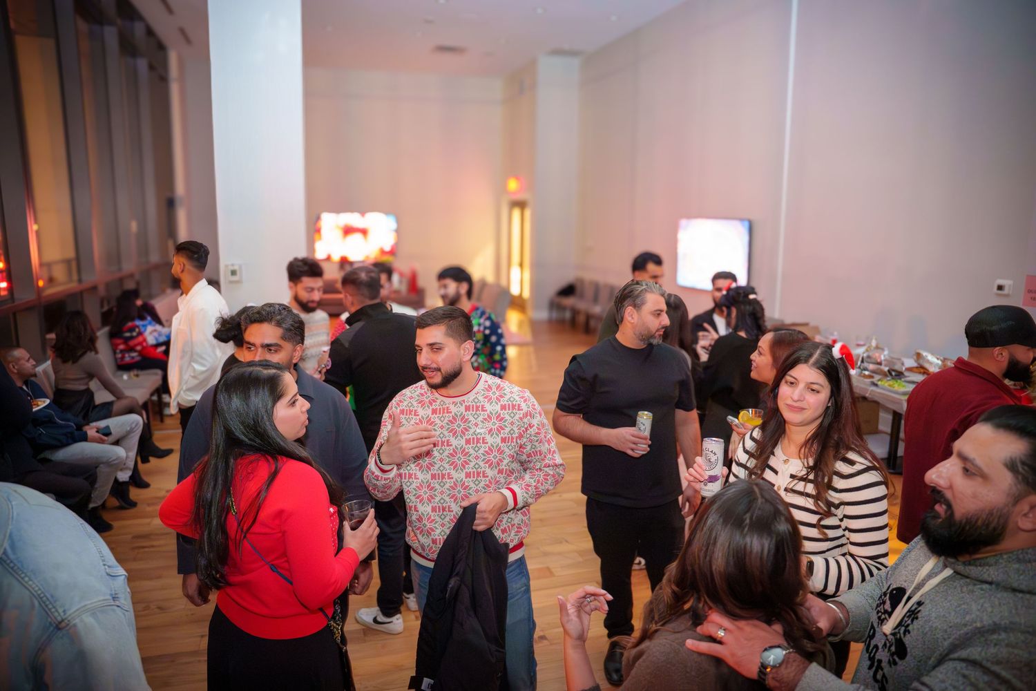 Large group of people mingling and dancing at an indoor social event.