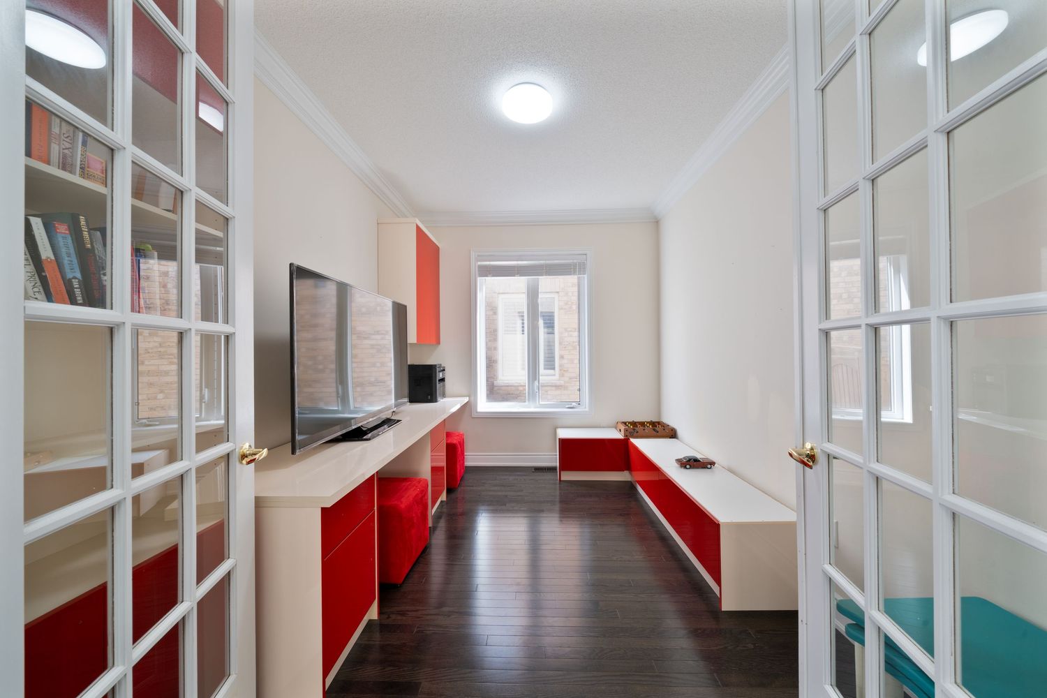 Modern office hallway interior with white walls and red accents featuring bright lighting and polished floors.