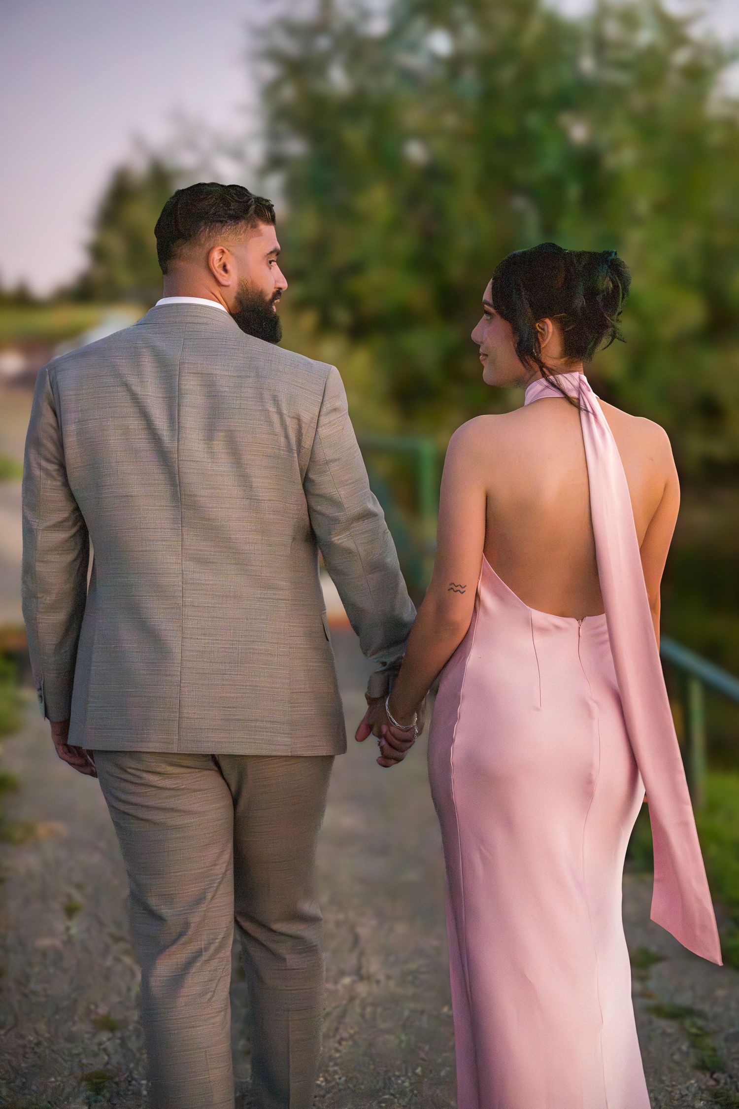 Couple walking together on nature path during evening photoshoot.