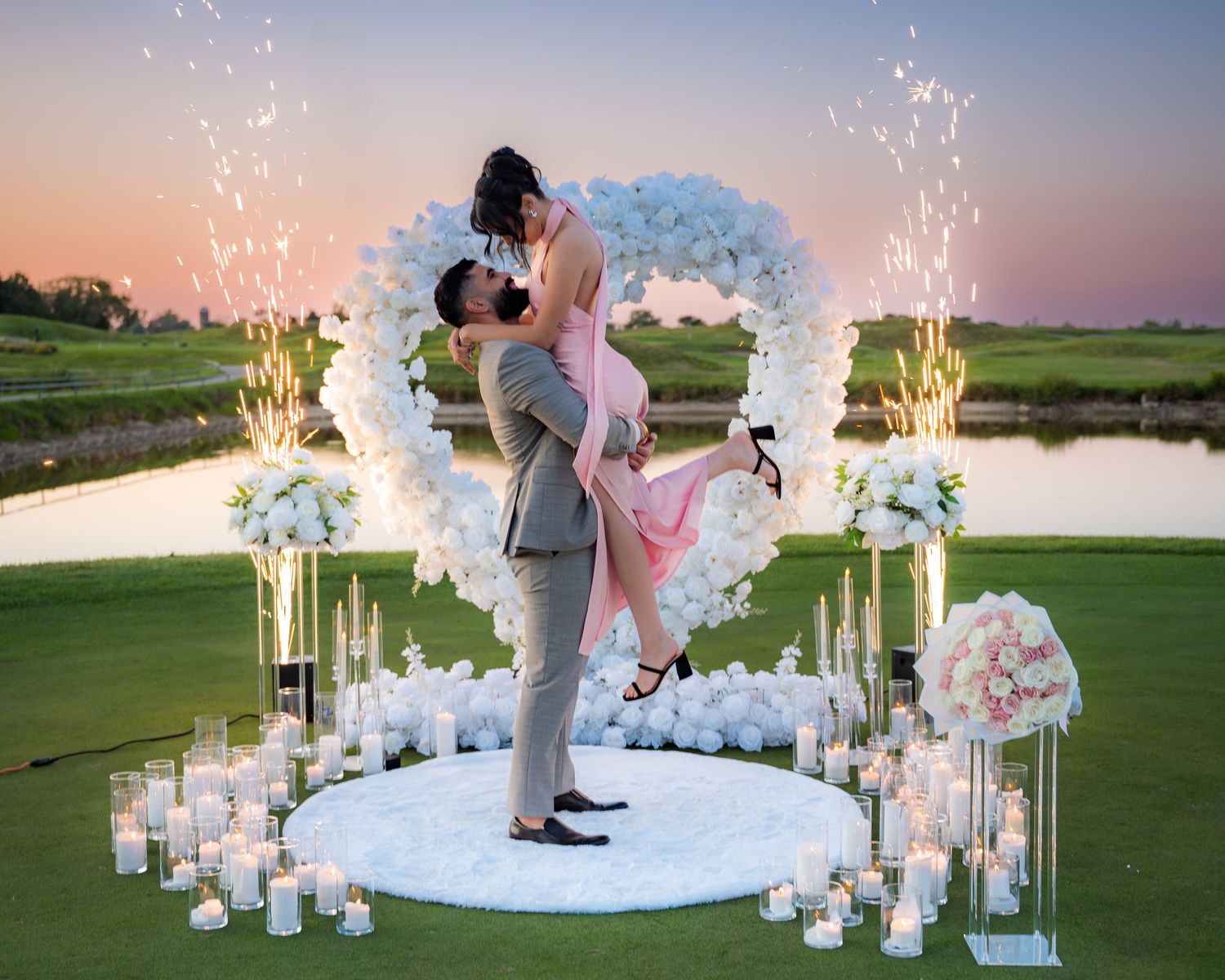 Magical proposal setting with floral arch and candlelight during golden hour.