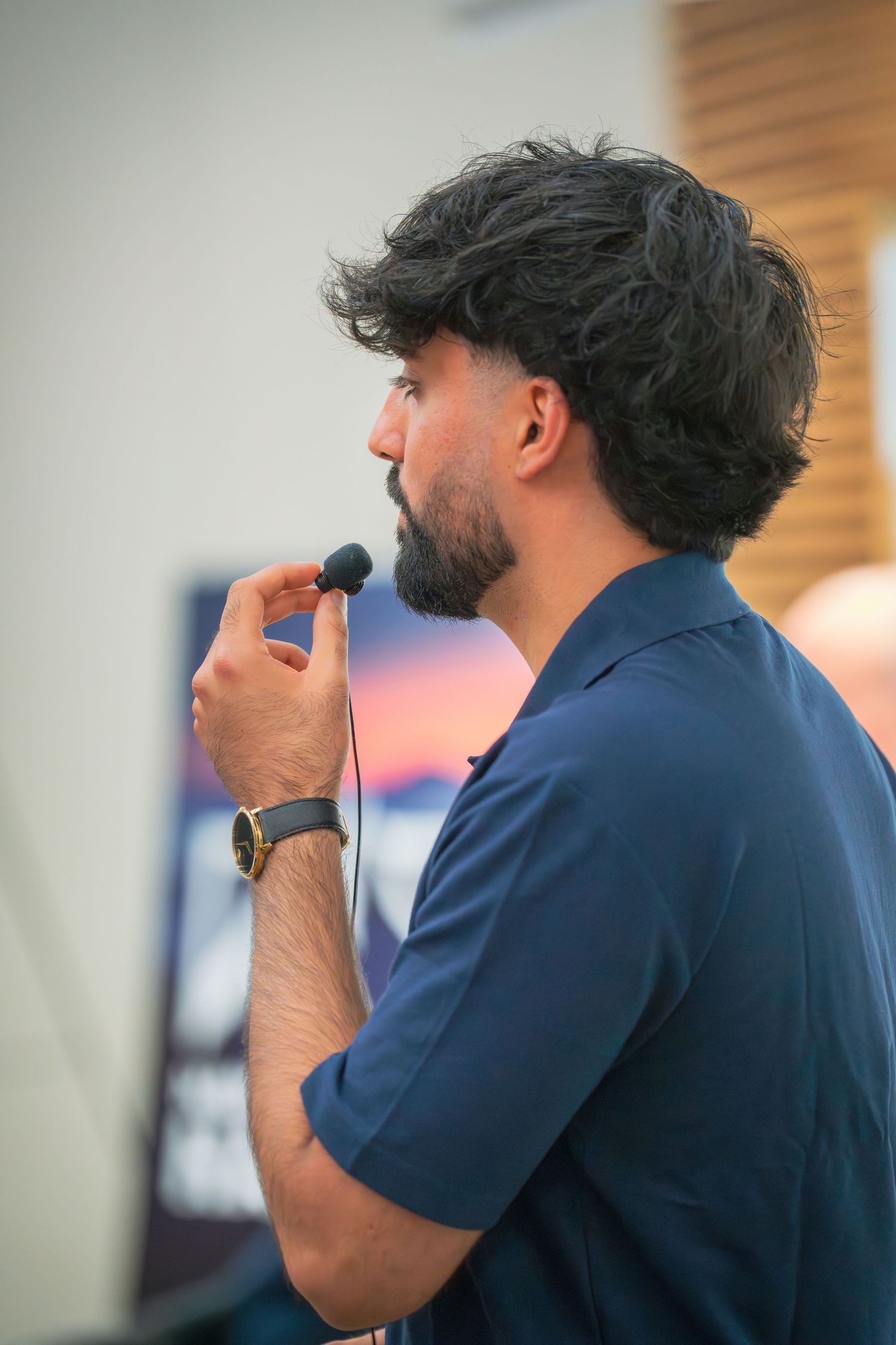 Side profile view of speaker in navy shirt during presentation.