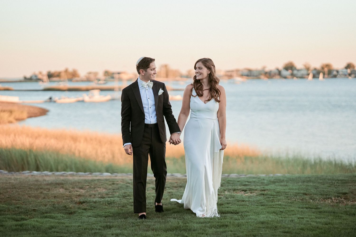 Nelstudios photographs a Jewish Wedding at The Inn at Longshore, Connecticut, where the couple walks together naturally during romantics.