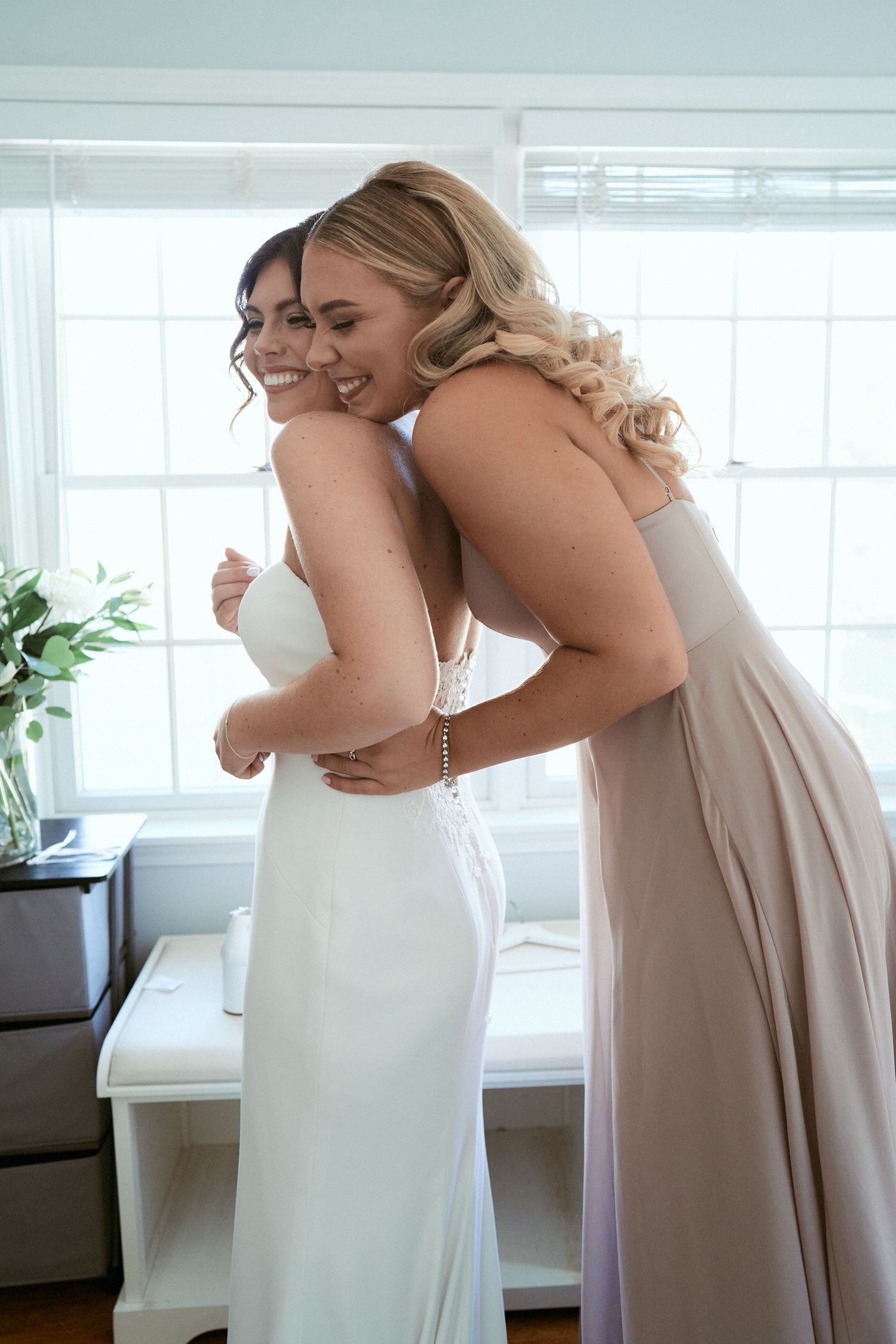 Nelstudios photographs a bride and her bridesmaid at the Briarcliff Manor in Westchester, NY, where they hold each other for a minute.