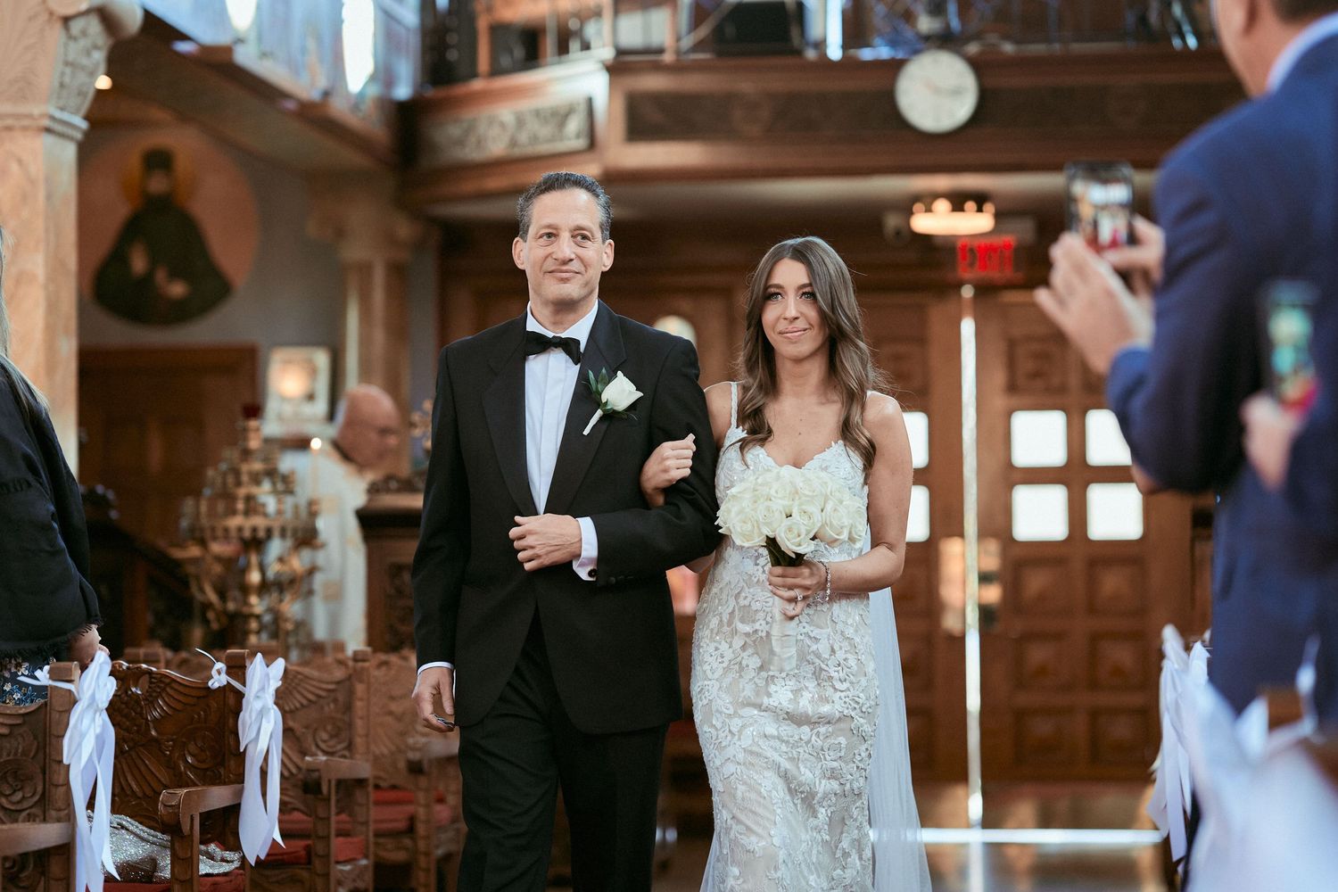 Nelstudios photographs a bride in Westchester, NY, where the bride walks down the aisle with her dad during the wedding ceremony.