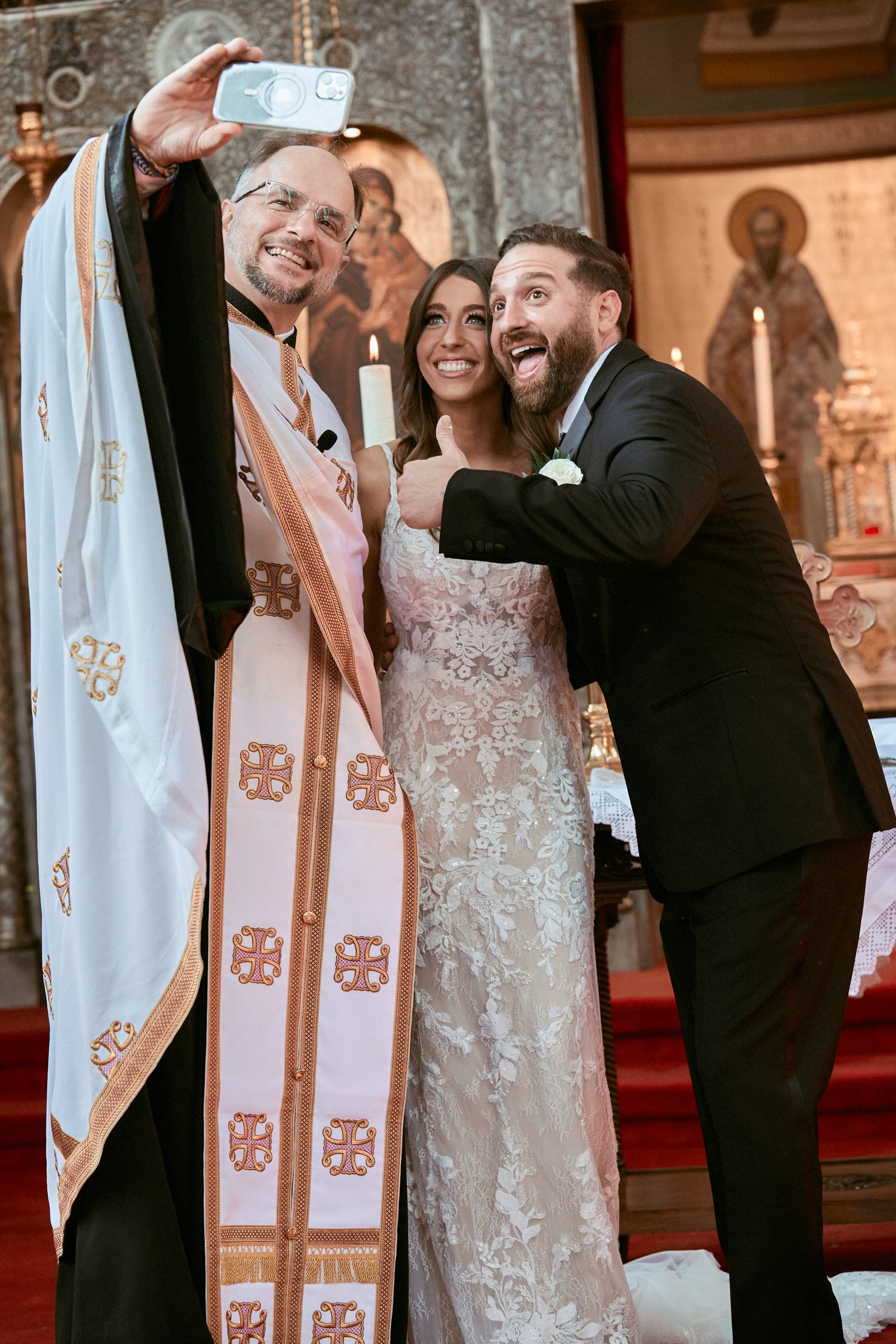 Nelstudios photographs a bride and groom in Westchester, NY, where they take a selfie at the church with the priest before the ceremony,