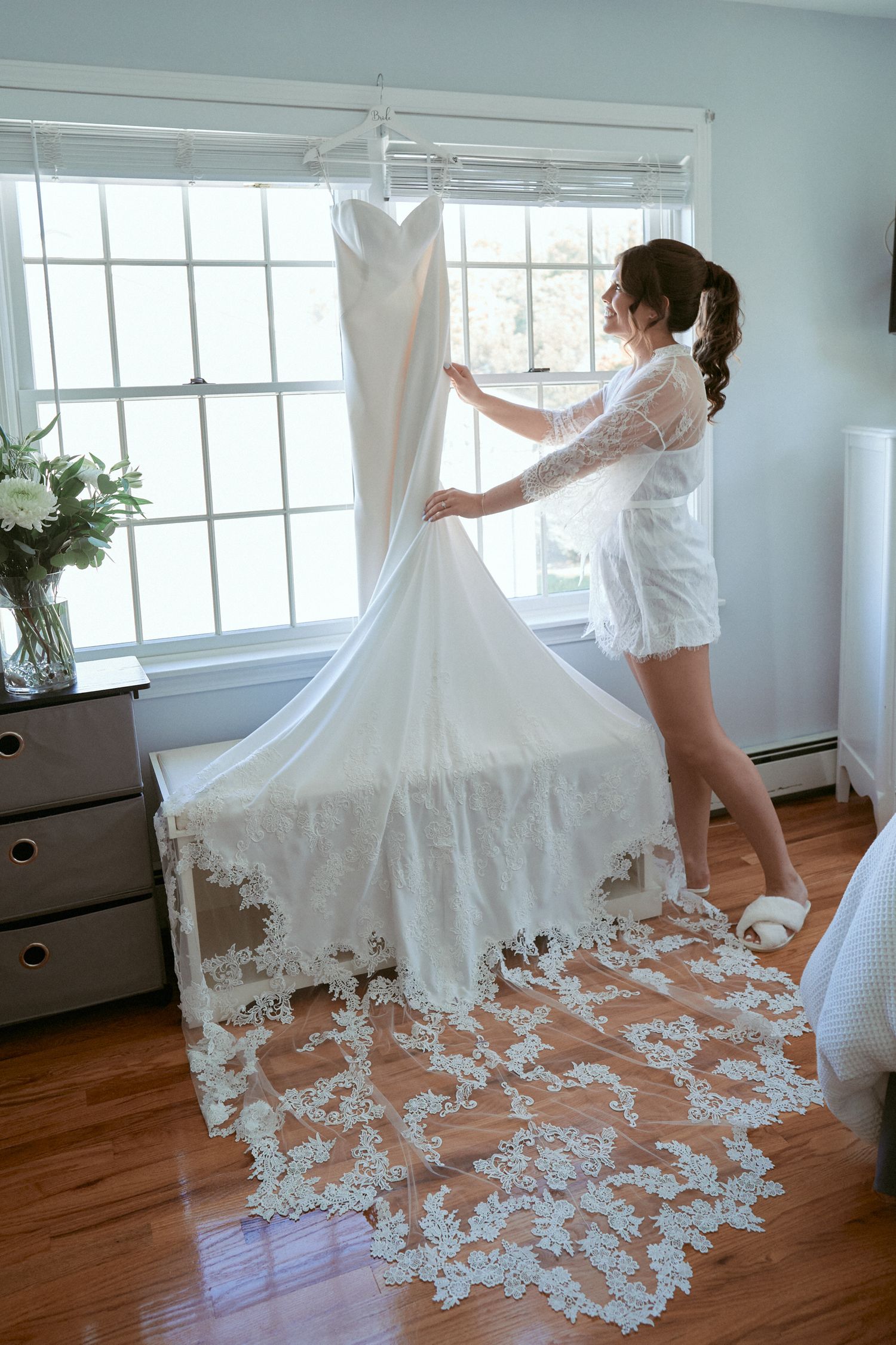 Nelstudios photographs a bride getting ready in Westchester, NY, where she looks at her dress in an authentic way.