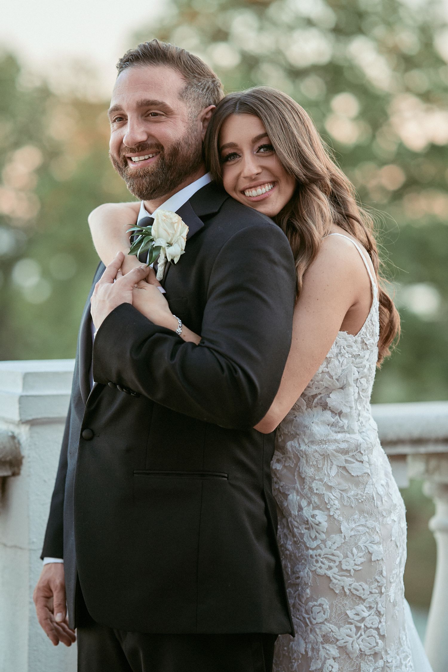Nelstudios photographs a bride and groom at the Surf Club On The Sound in Westchester, NY, where they walk together with their hands up.