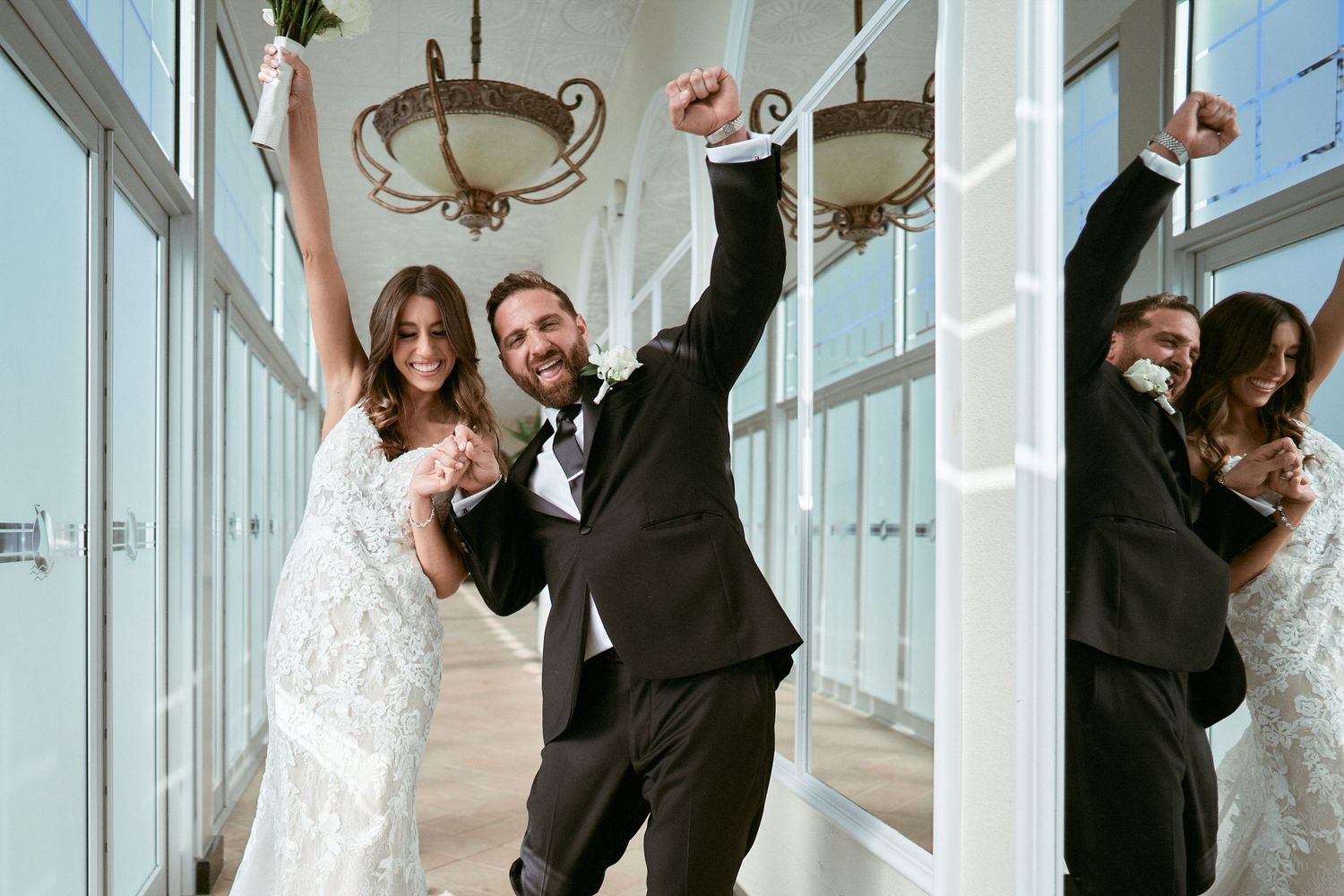 Nelstudios photographs a bride and groom at the Surf Club On The Sound in Westchester, NY, where they walk together with their hands up.