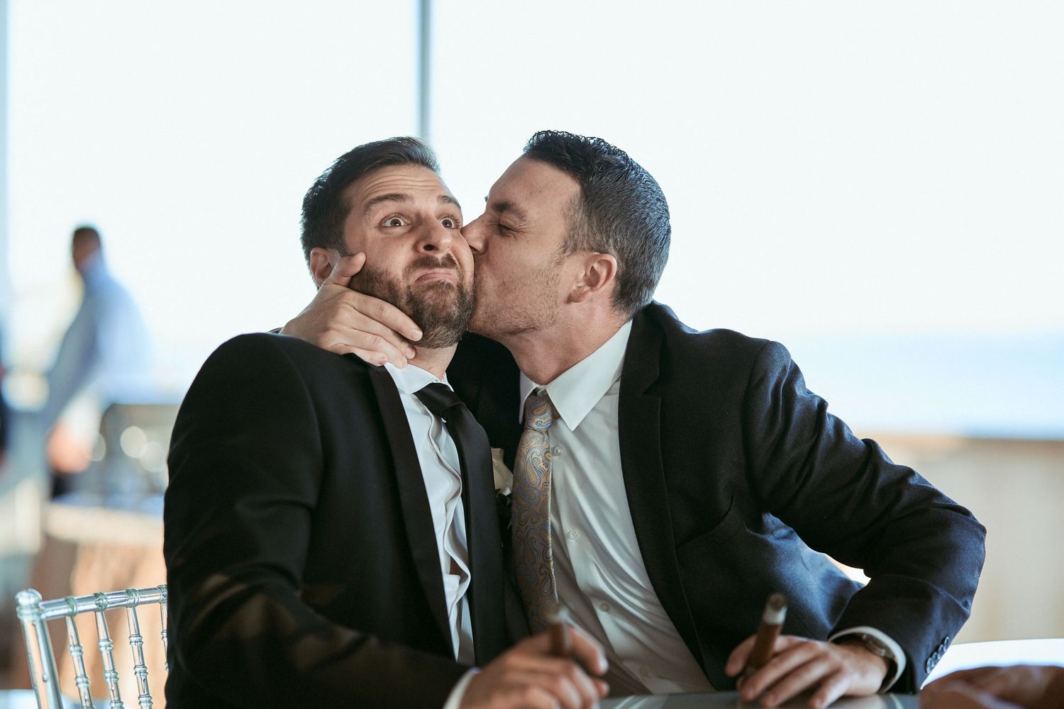 Nelstudios photographs wedding guests in Westchester, NY, where one of the guests kisses the other on the cheek.
