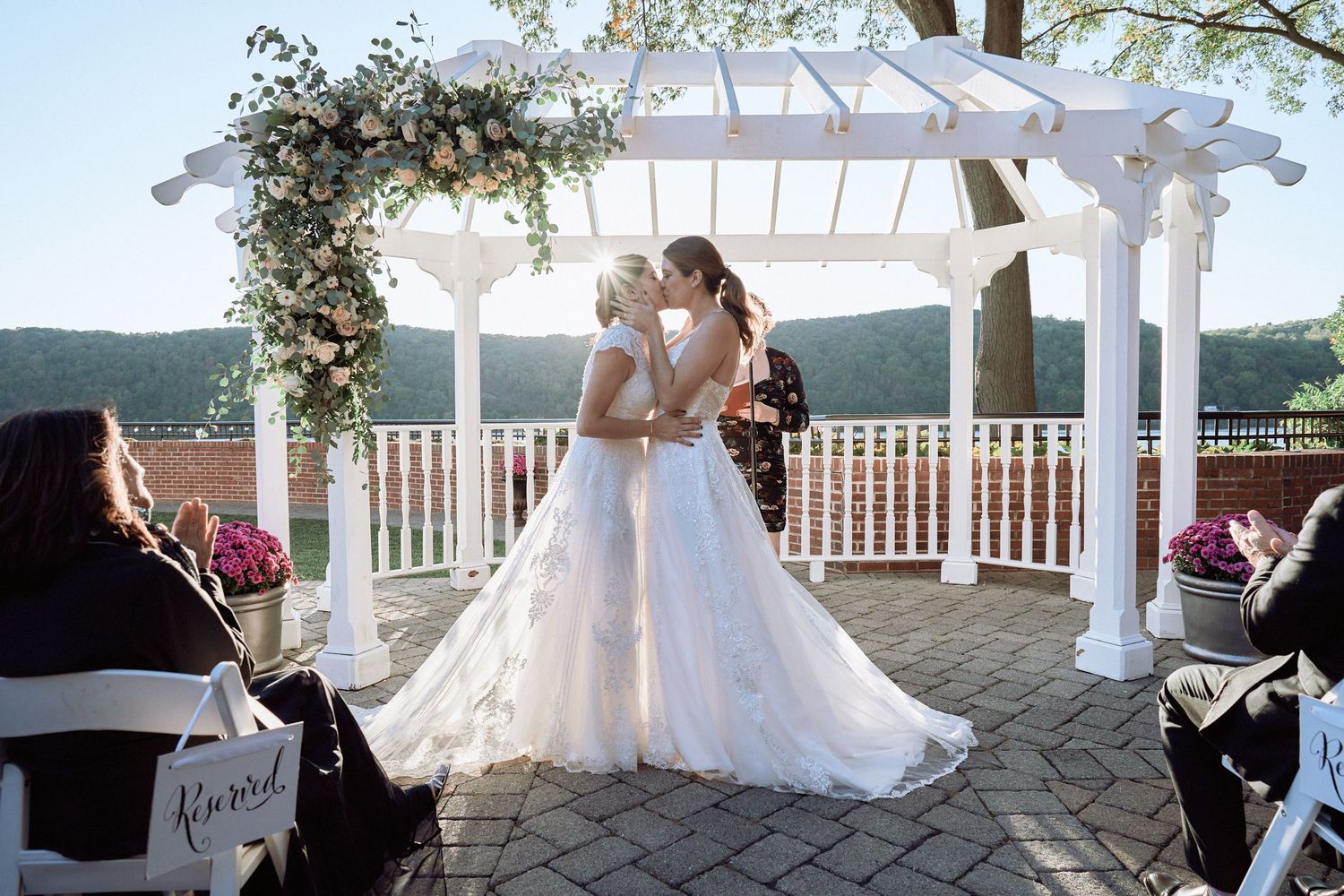 Nelstudios photographs two brides at The Grandview in Poughkeepsie, NY, where the brides kiss during the ceremony in an LGBTQ wedding.
