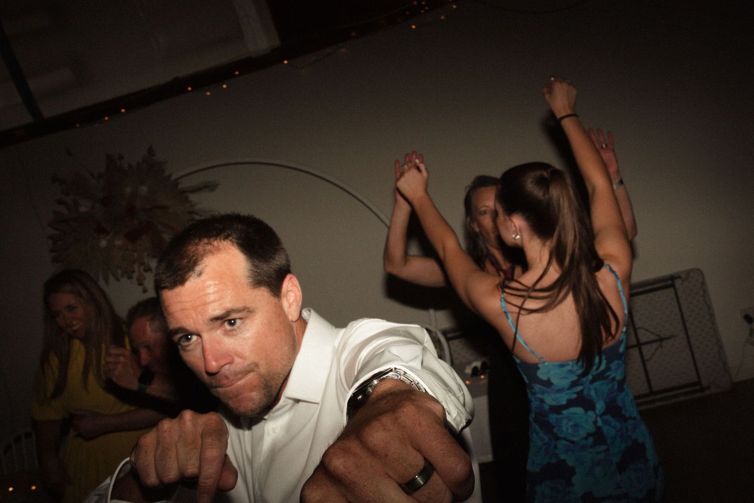 Energetic dancing captured at a nighttime celebration under dim lighting.