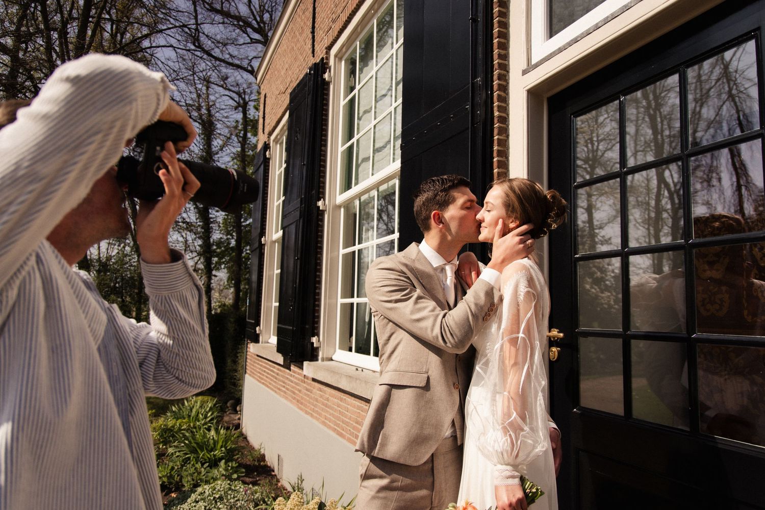 Sfeerbeeld van Bas Verburg die een bruidspaar fotografeert