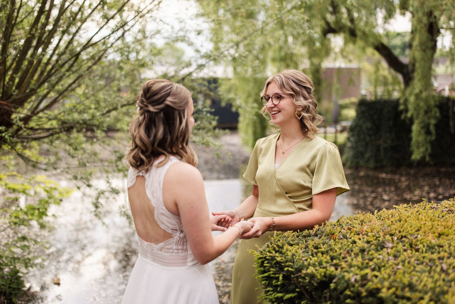 Two people share a tender moment among flowering bushes in a garden setting during springtime.