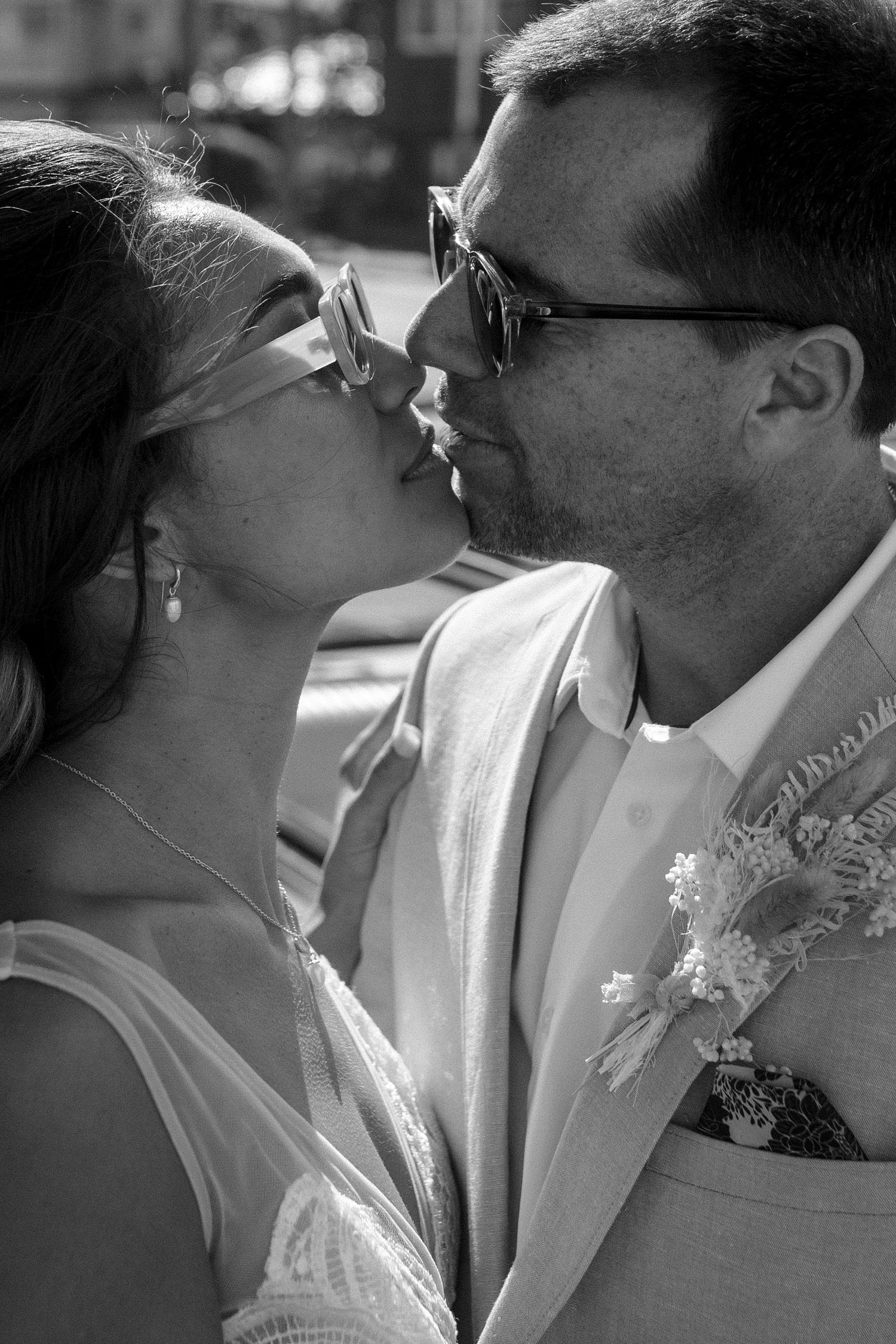 A close-up black and white portrait of a tender moment between newlyweds.