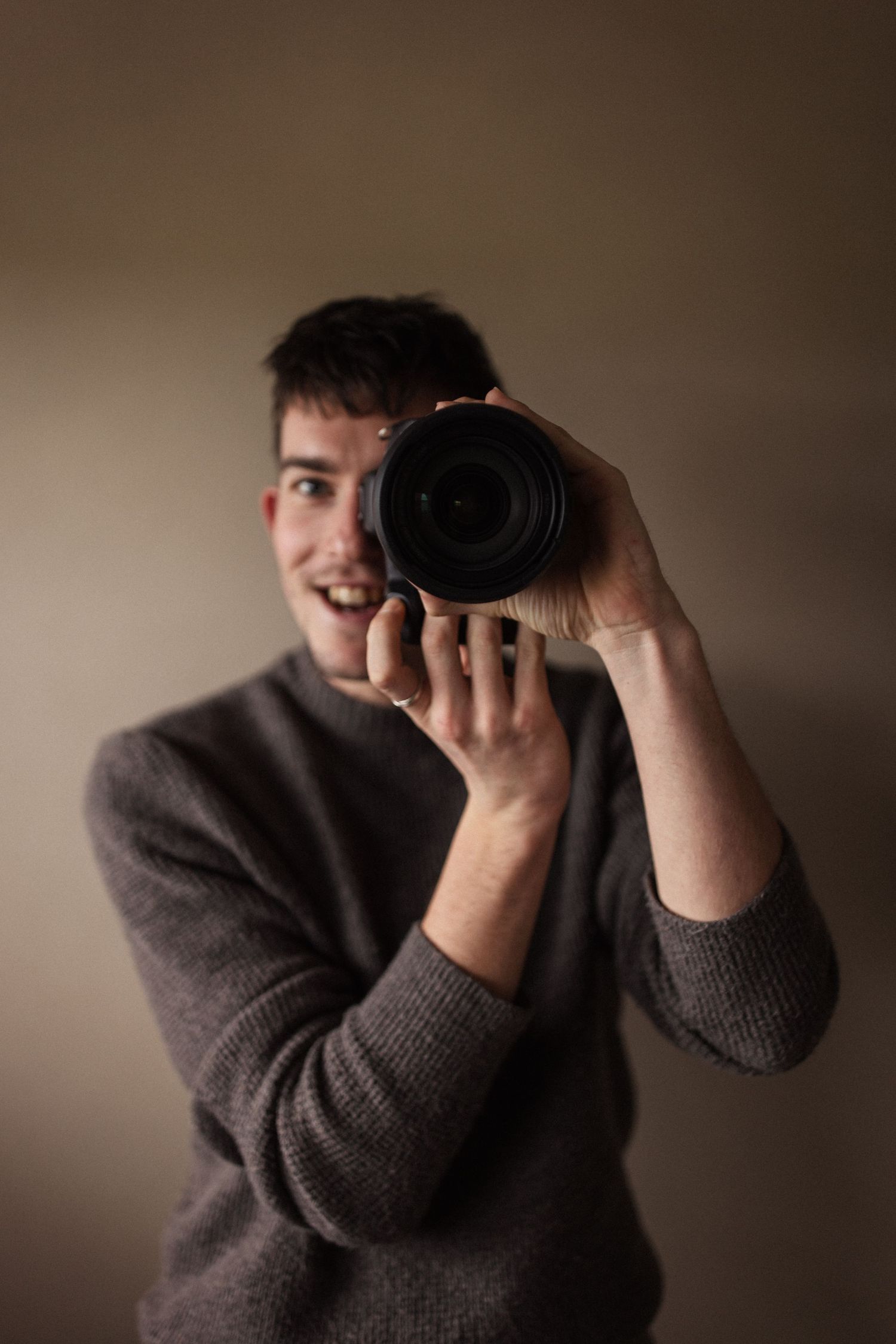 Fotograaf die met een camera voor zijn gezicht de lens in fotografeert.