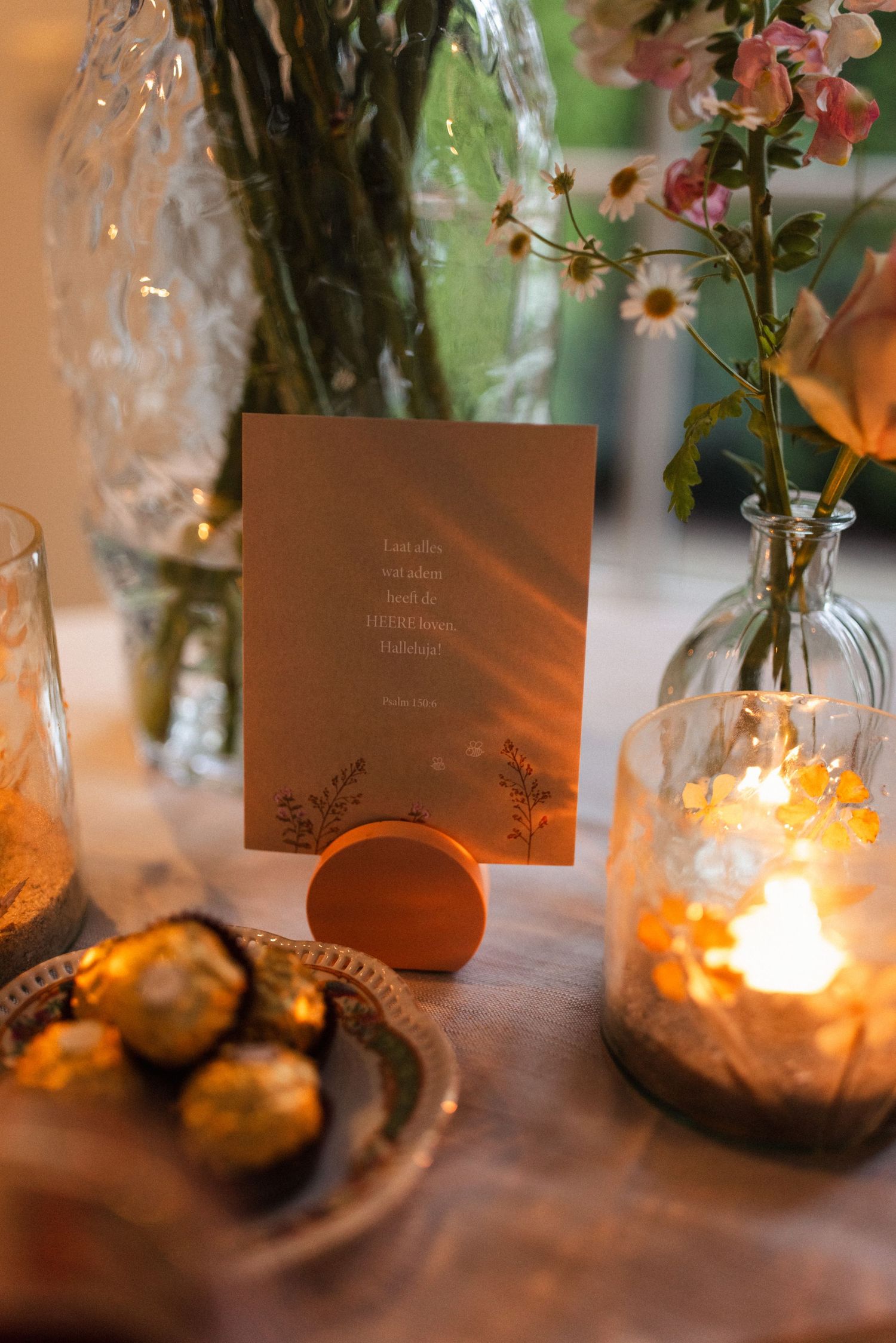 Intimate wedding table setting with glowing candlelight, simple floral arrangements, and place cards creating a romantic ambiance.