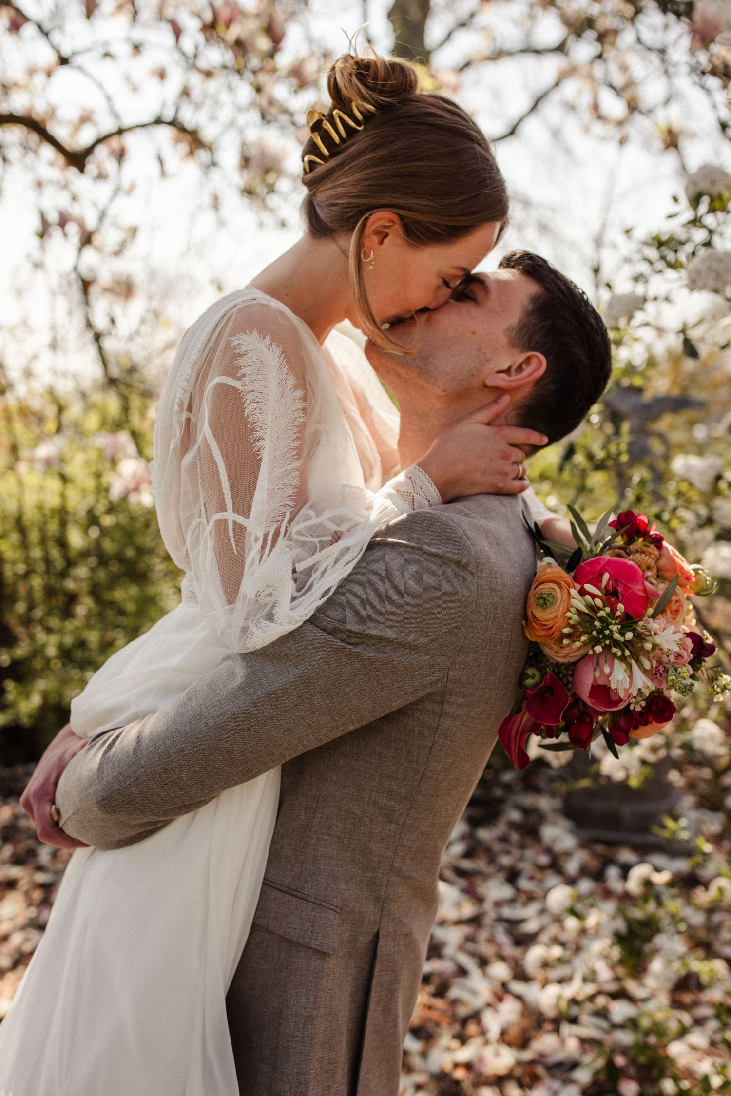 A couple walking down a rustic dirt path surrounded by lush greenery on their wedding day.