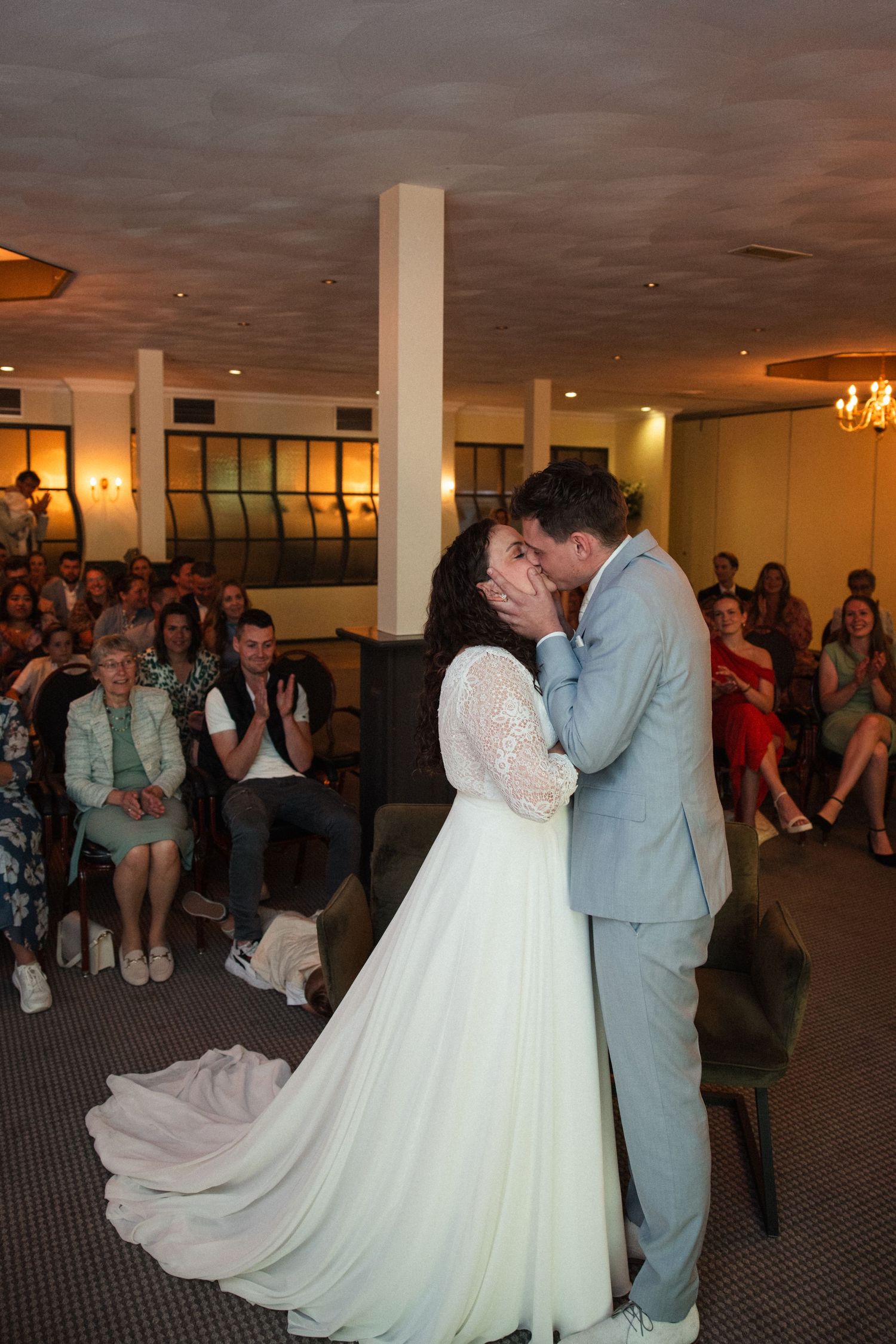 First dance wedding moment in an indoor venue with guests watching in background.