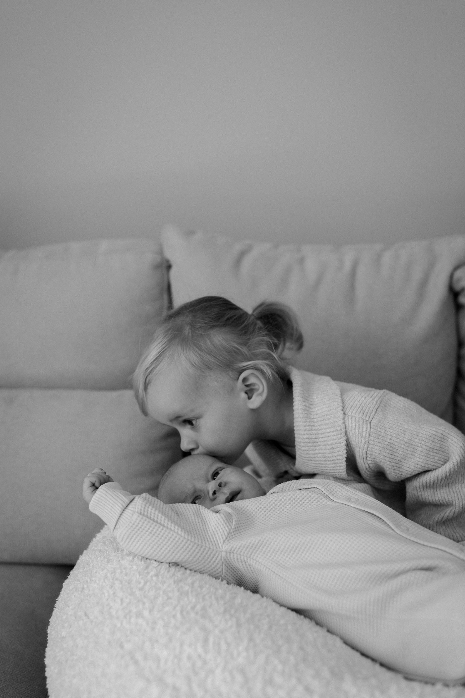 Sweet tender moment captured in black and white on a couch.