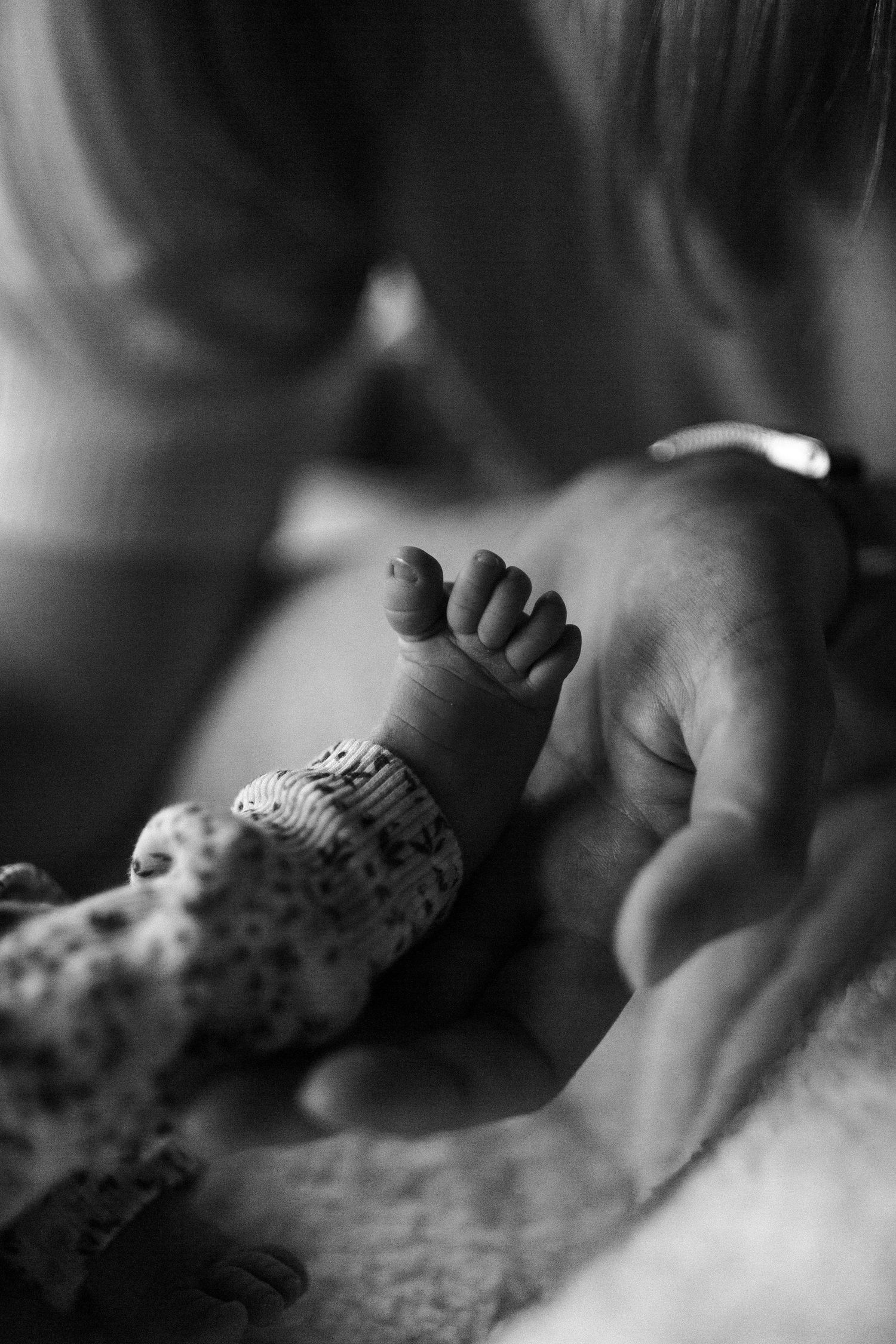 Zwart/wit foto van een piepklein babyvoetje.