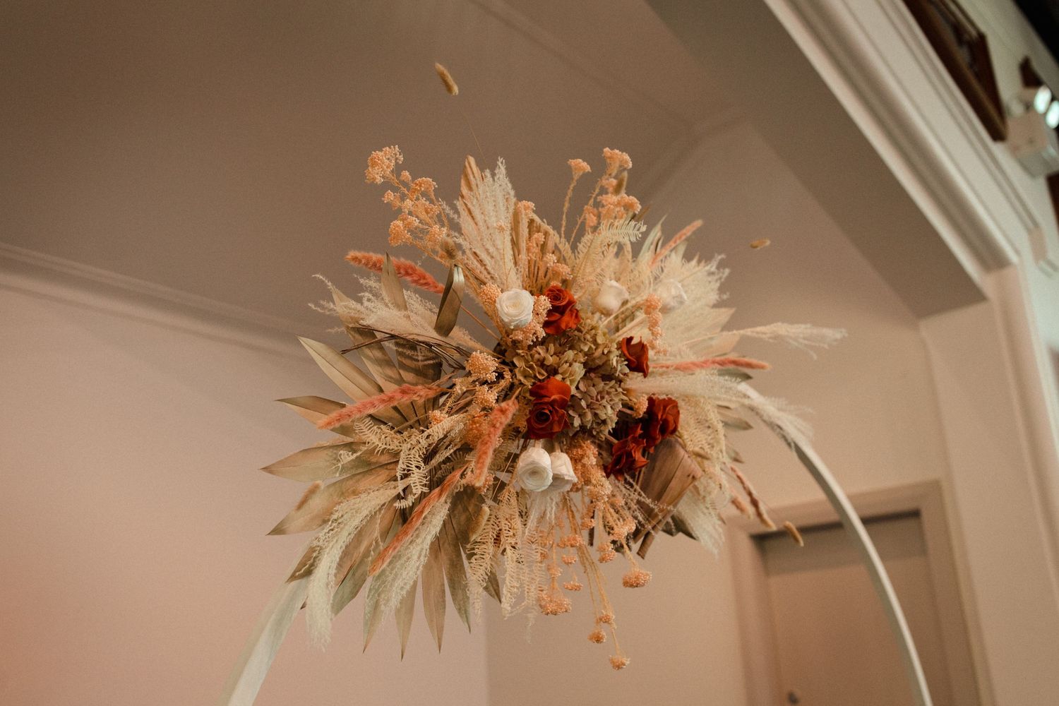 Dried floral arrangement in peach and cream tones hanging from the ceiling.