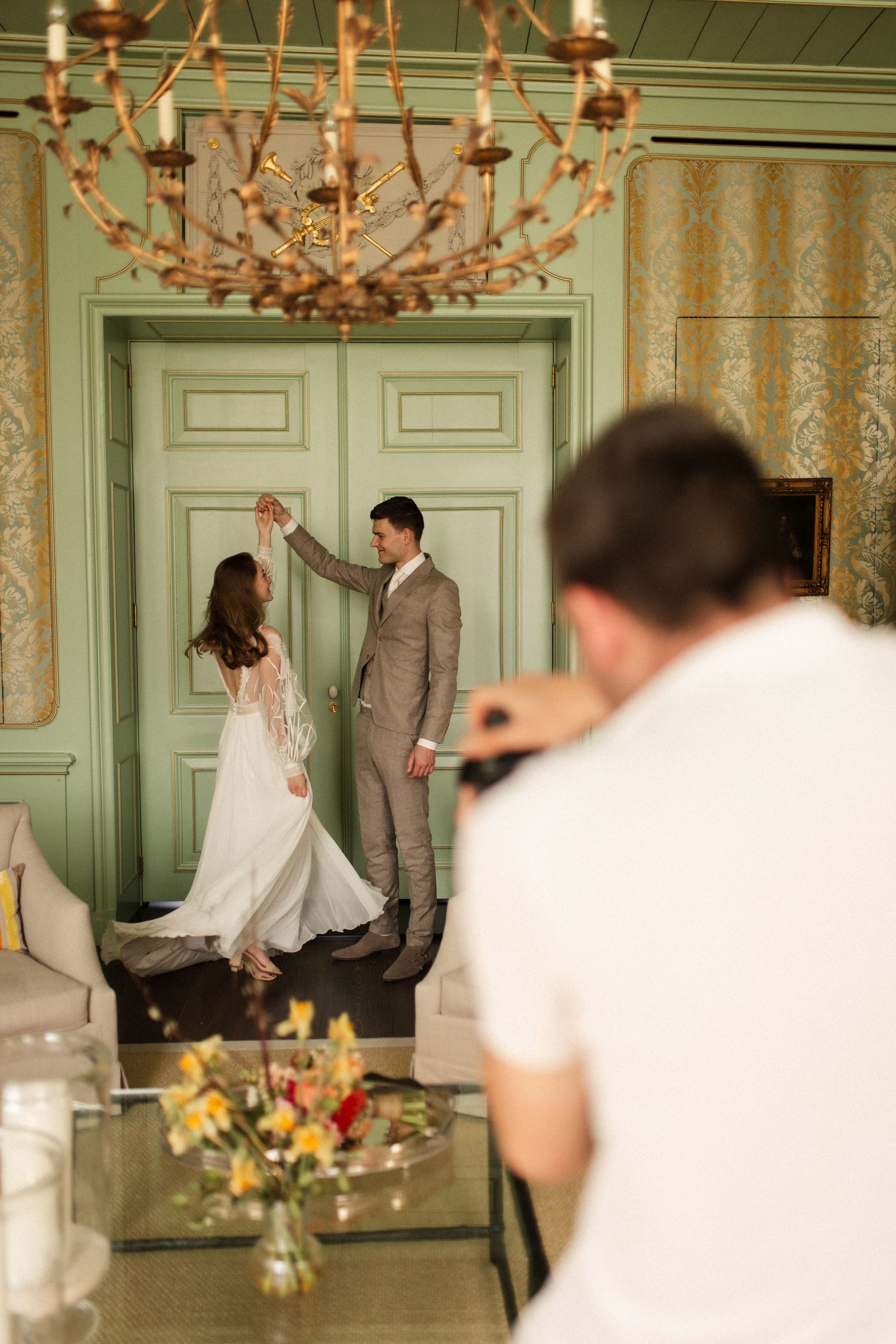 Op deze foto zie je de fotograaf aan het werk die een bruidspaar op de foto zet. Het bruidspaar danst.