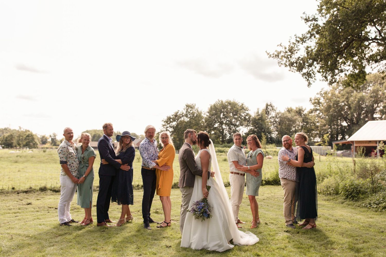 groepsfoto met het bruidspaar middenin en koppels eromheen.