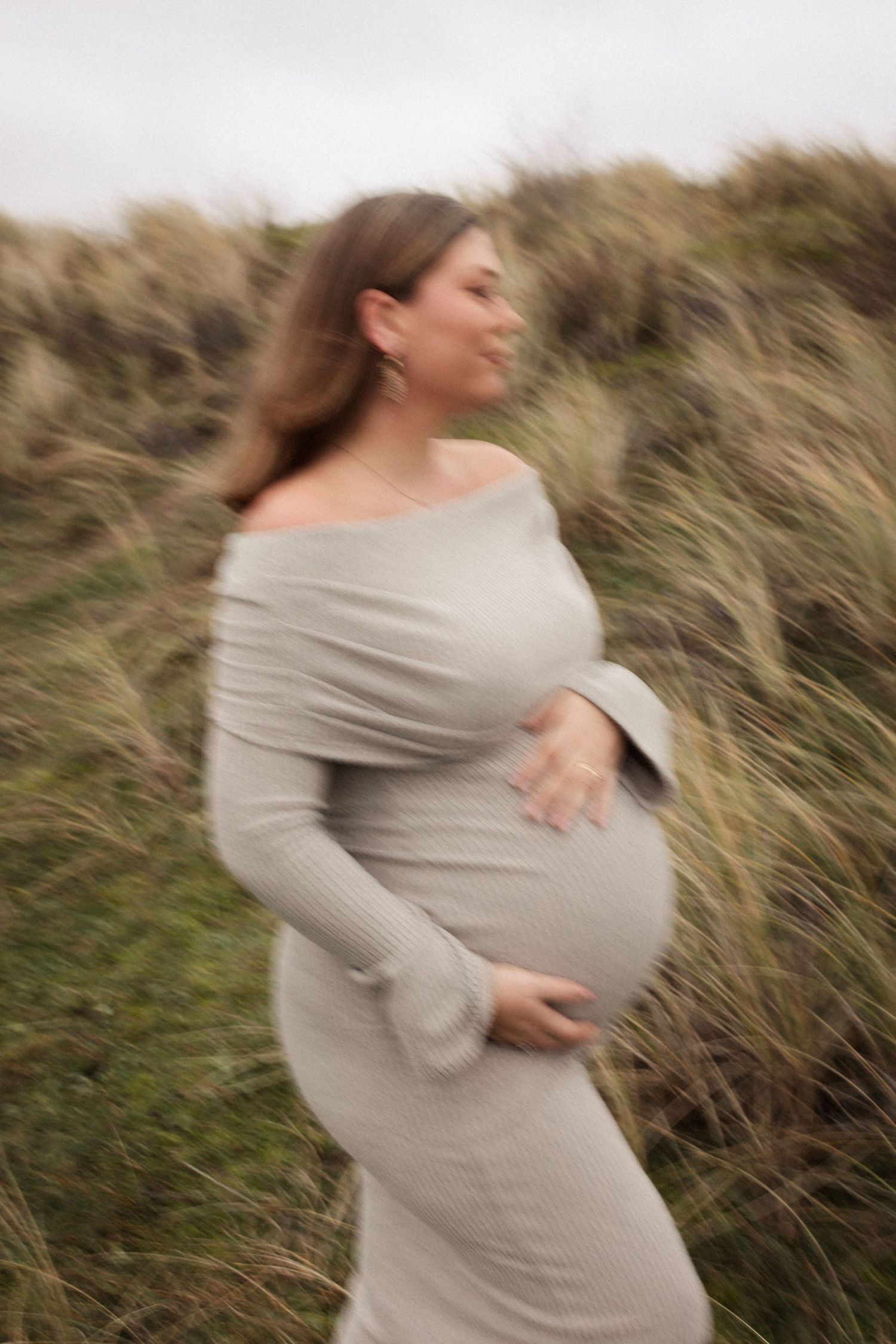 Vrouw houd haar zwangere buik vast. Foto heeft bewegingonscherpte.
