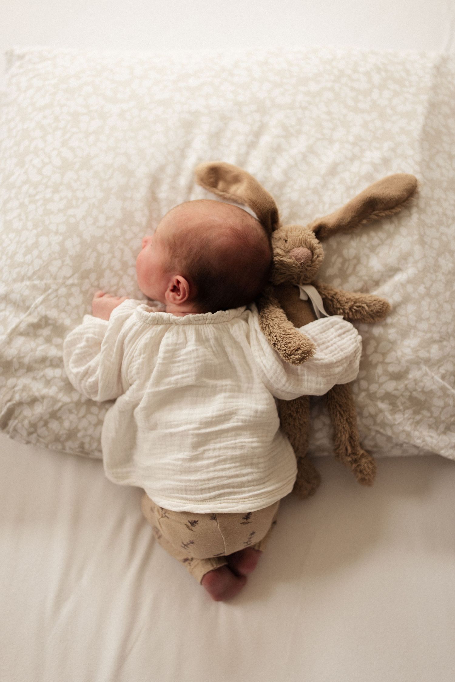 Newborn baby die rustig ligt te slapen met haar favoriete knuffel