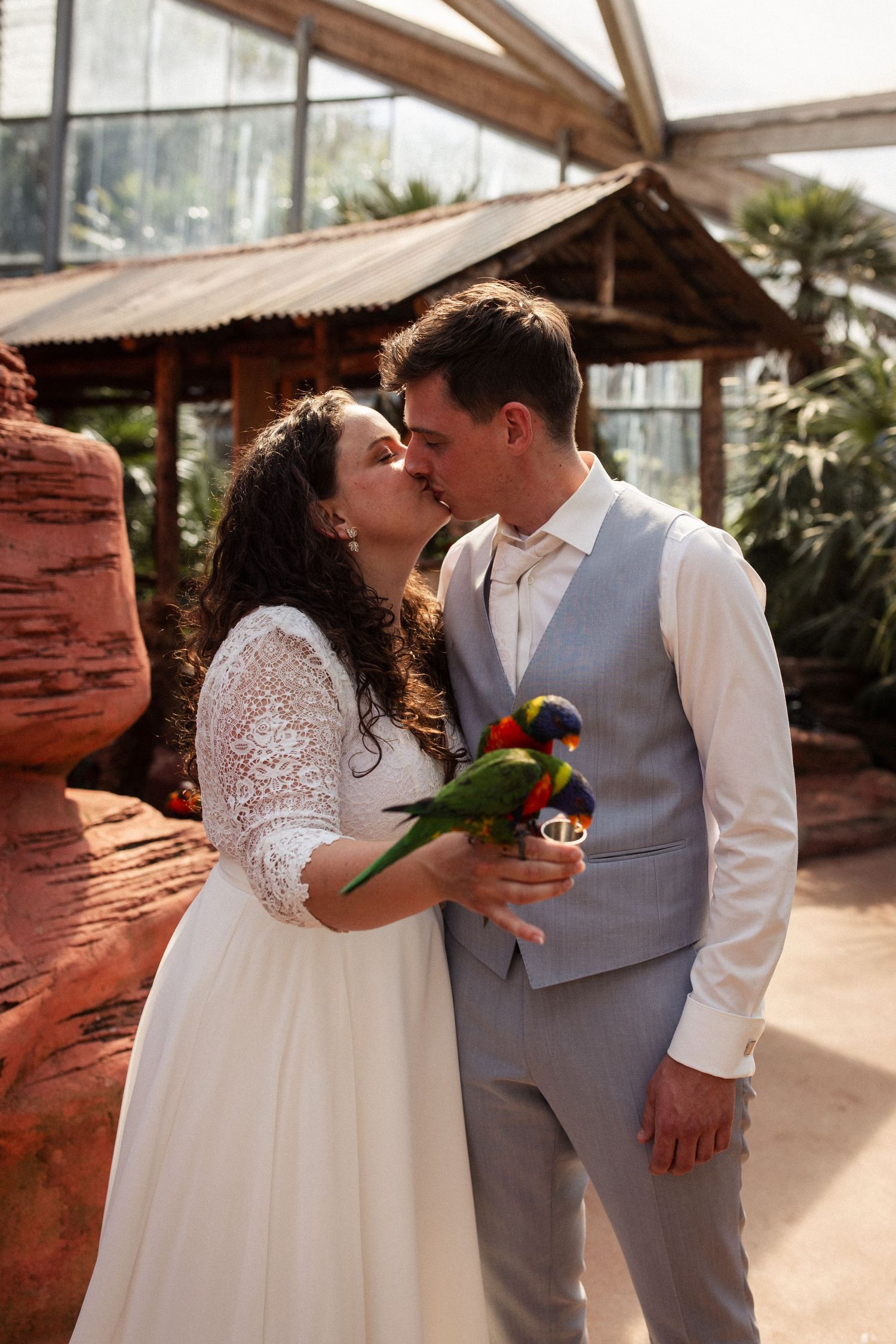 Romantic couple shares intimate moments in front of a red rock wall outdoors.