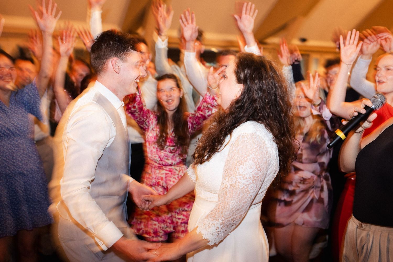Bruidspaar danst temidden hun gasten. Door flitstechniek is er een bepaalde onscherpte.