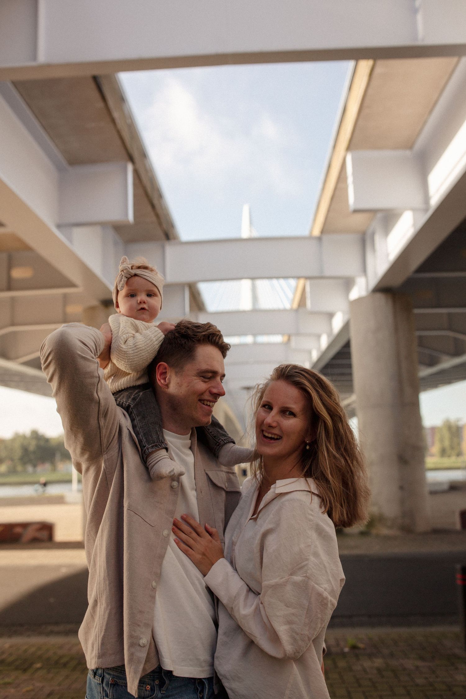 Joyful family laughing together under an urban architectural structure with skylights.