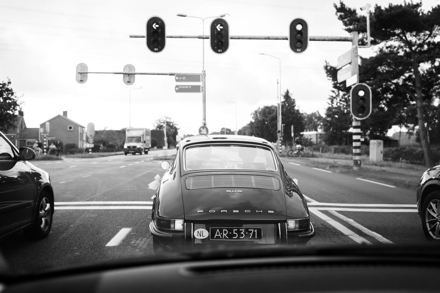 Zwart/wit beeld van een Porsche trouwauto die onderweg is.