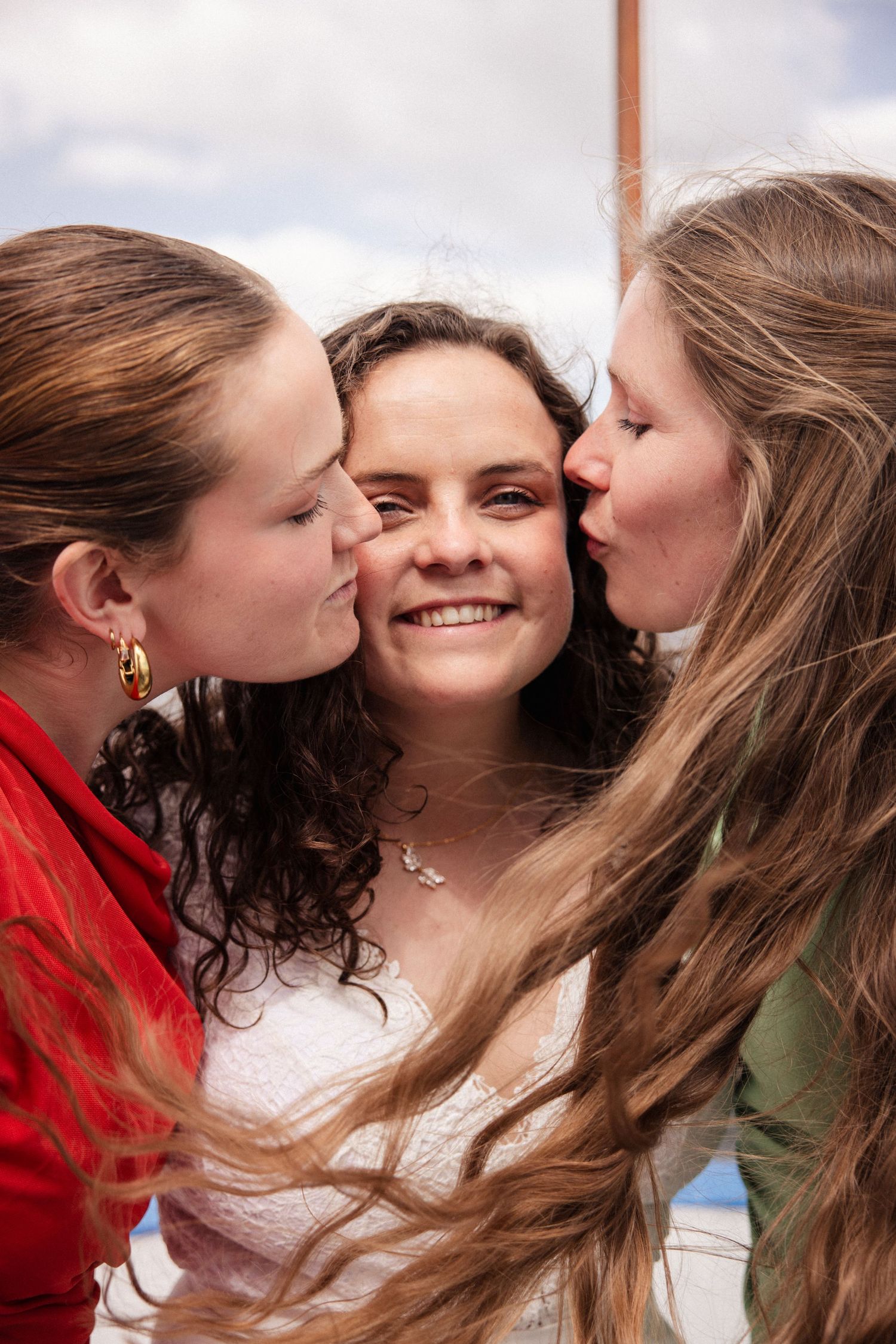 Three friends share an intimate moment of joy and laughter together in this candid emotional shot.