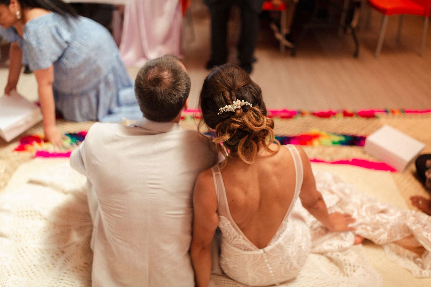 A couple sits together on the floor during their wedding reception celebration.