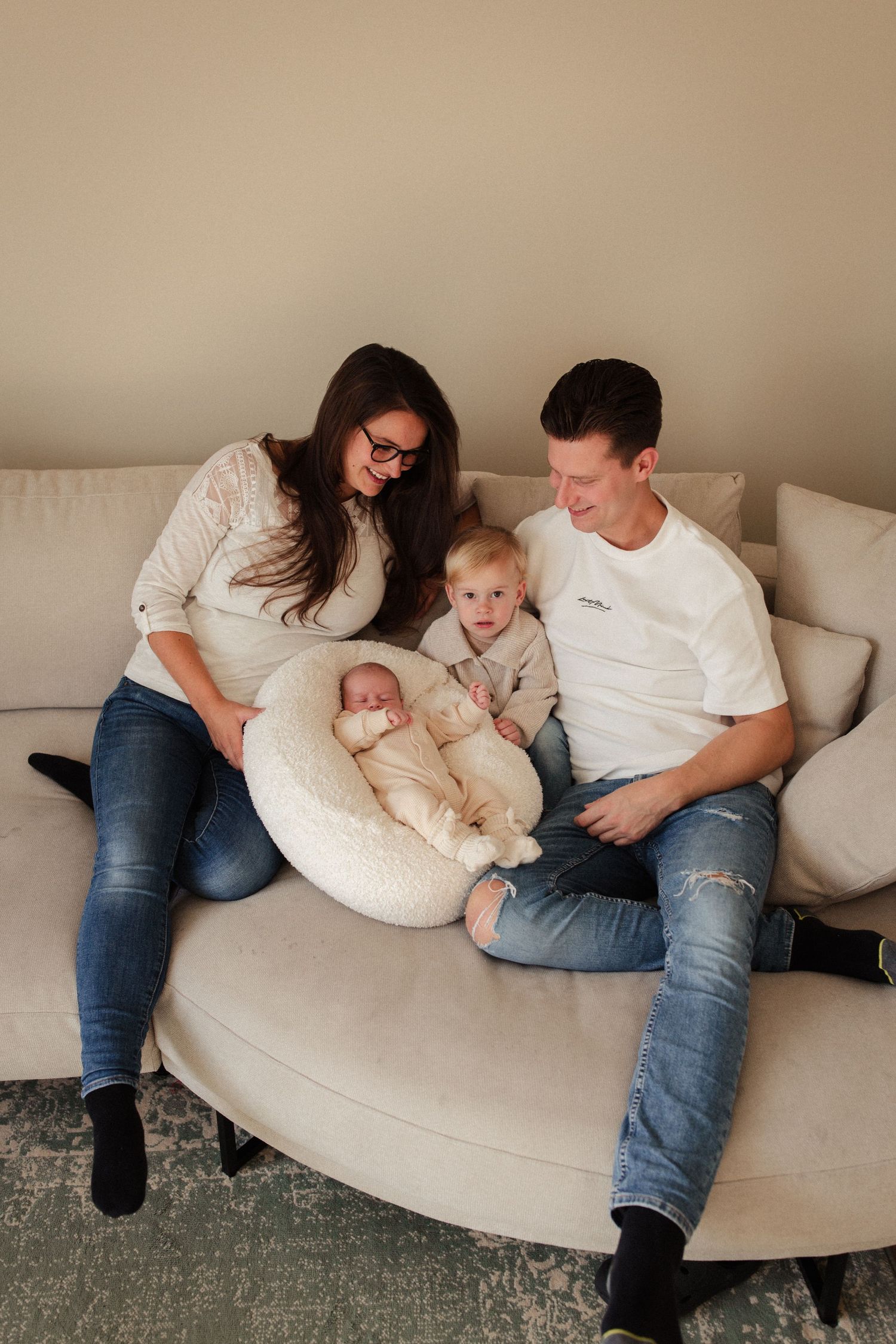 Family relaxing together on curved gray sectional sofa.