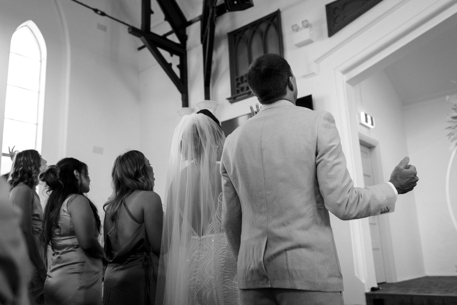 Black and white photo of a wedding ceremony in a traditional church setting.