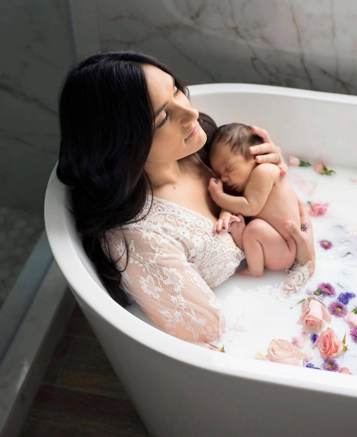 Creative newborn photography with baby  and mom in floral milk bath surrounded by flowers. captured by kayleigh kannady photography