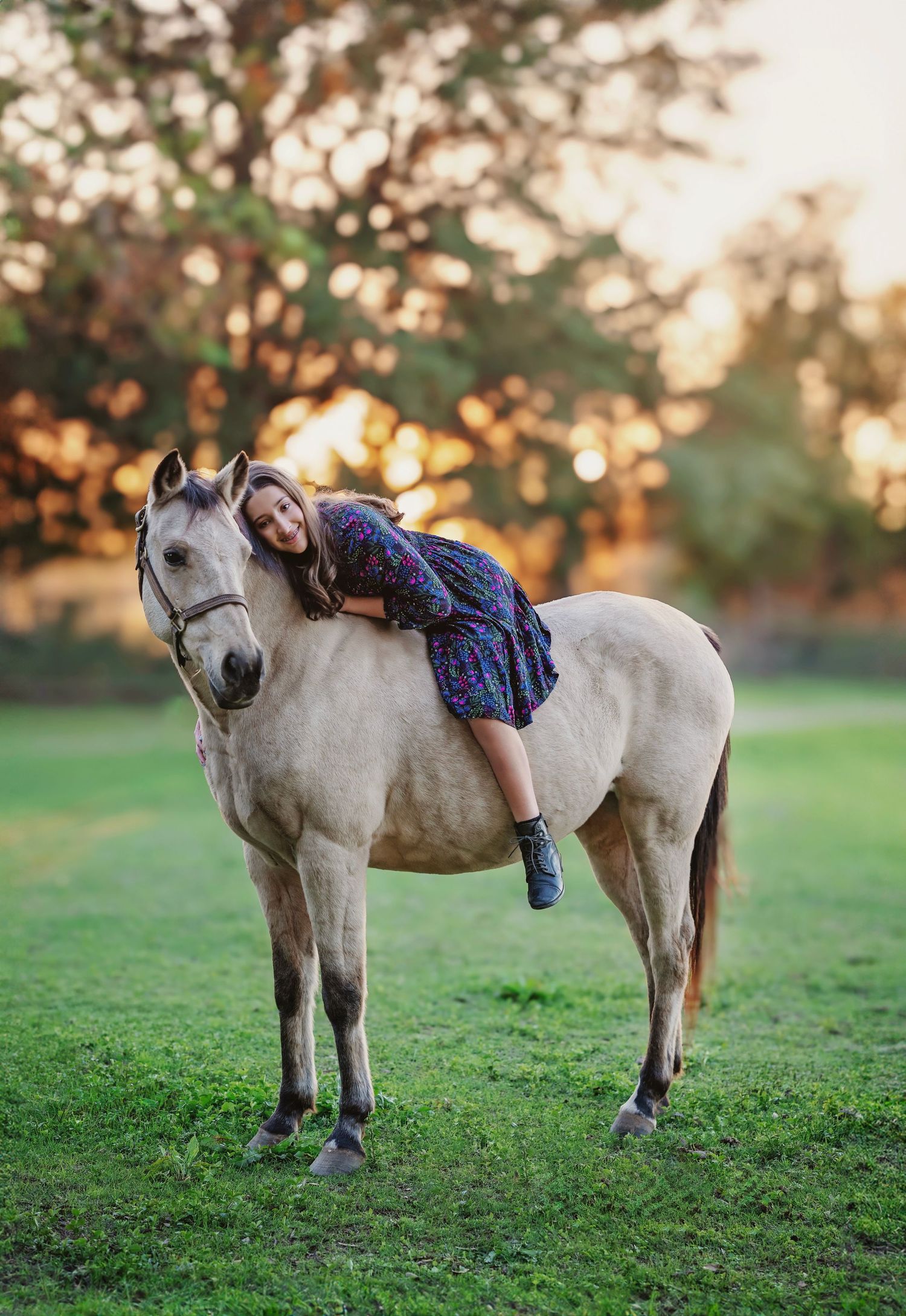 Elegant horse and rider portrait with a beautiful teen girl on a cream colored horse at sunset in tomball texas