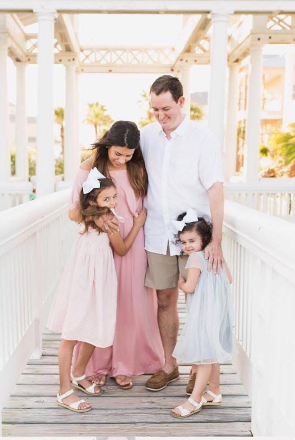 Beach family portrait with parents and two daughters smiling in the ocean – Kayleigh Kannady Photography family session on the beach.