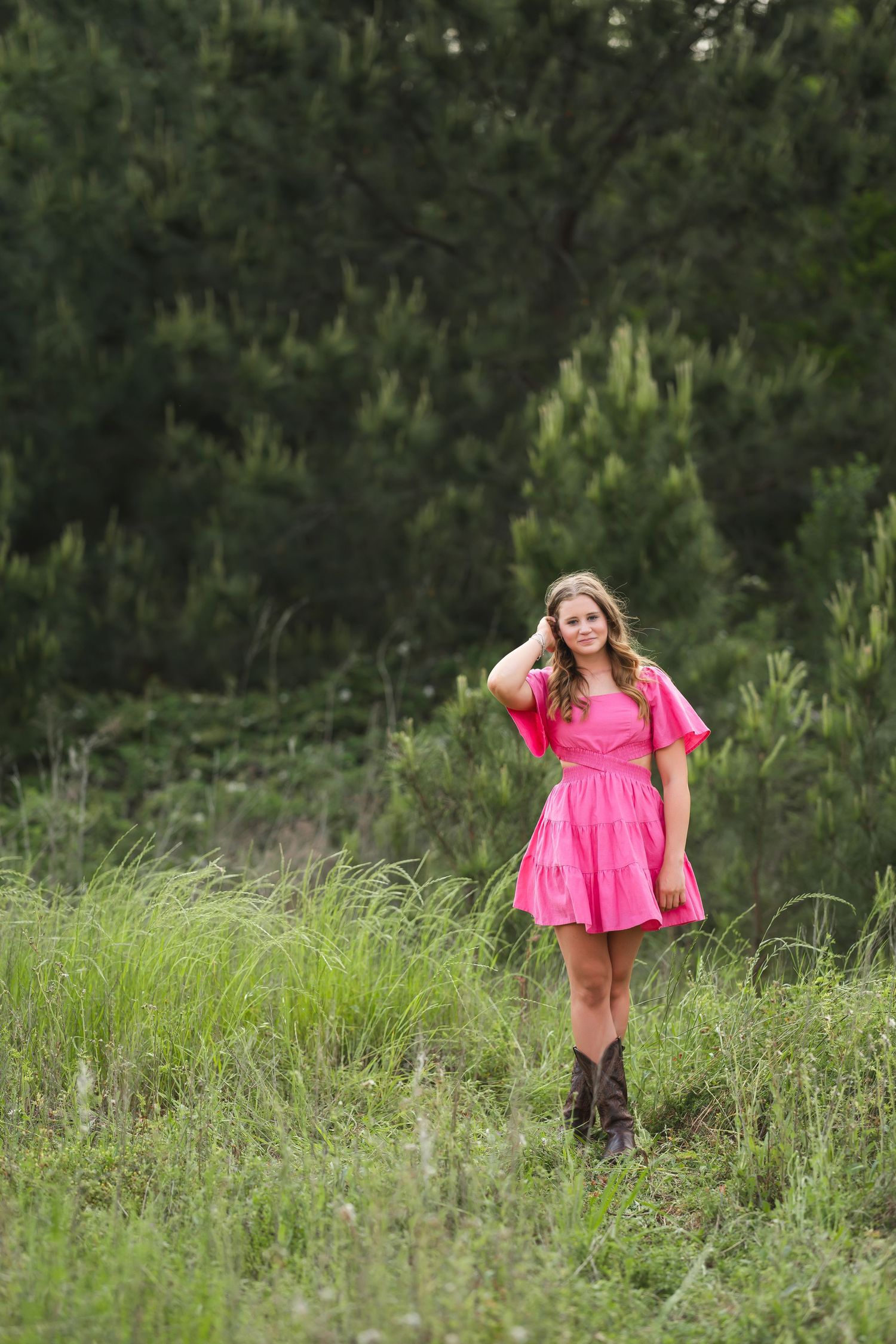 teenager playfully posing in a grassy field