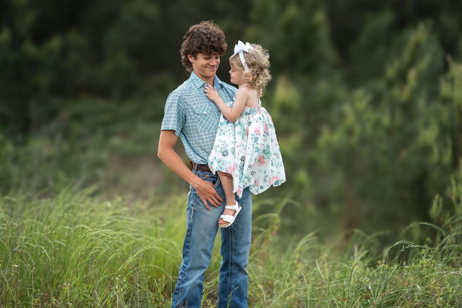 playful portrait of siblings at sunset in a grassy field