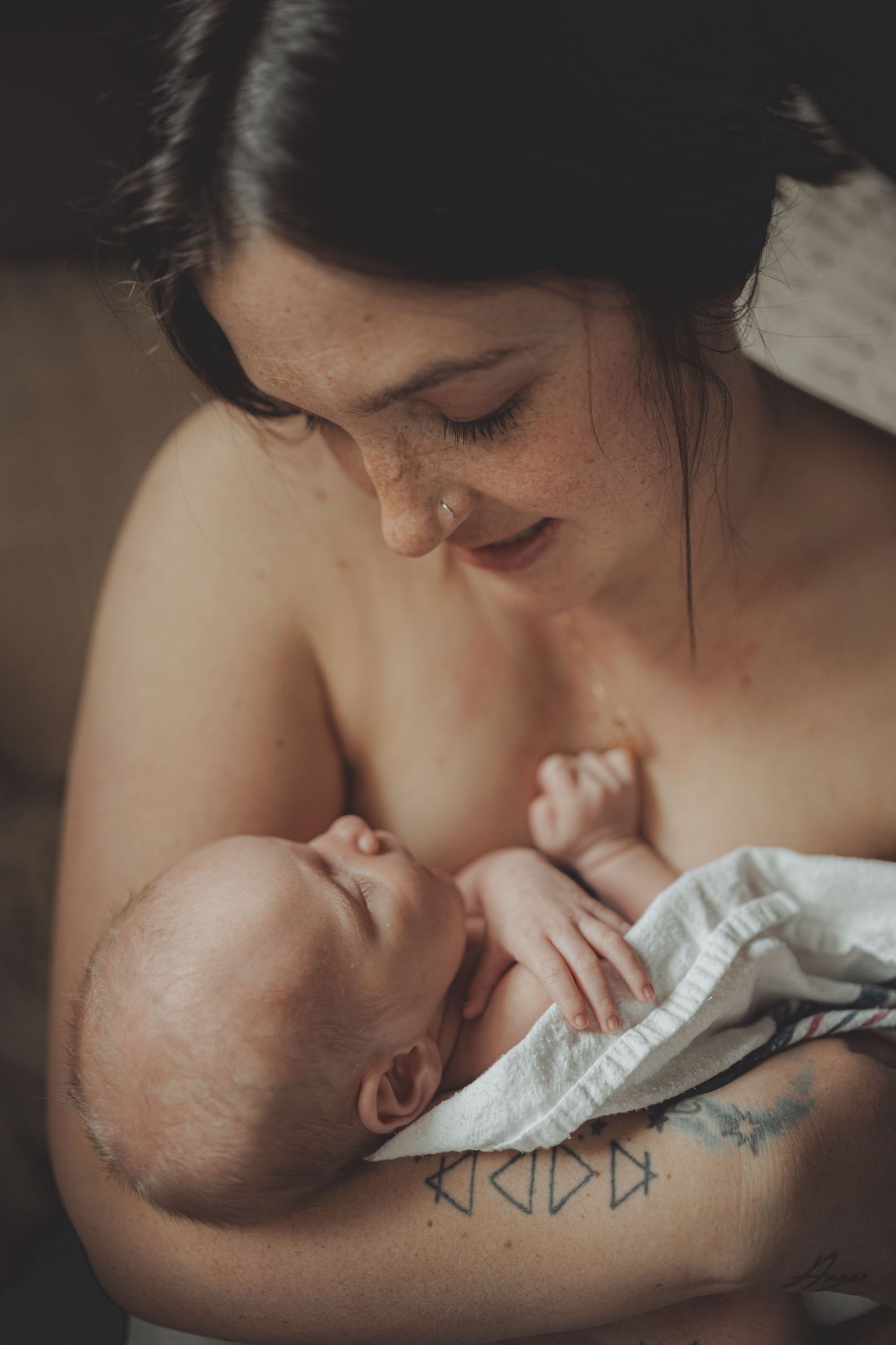 A tender moment of a parent kissing their sleeping baby in a series of intimate black and white photographs.