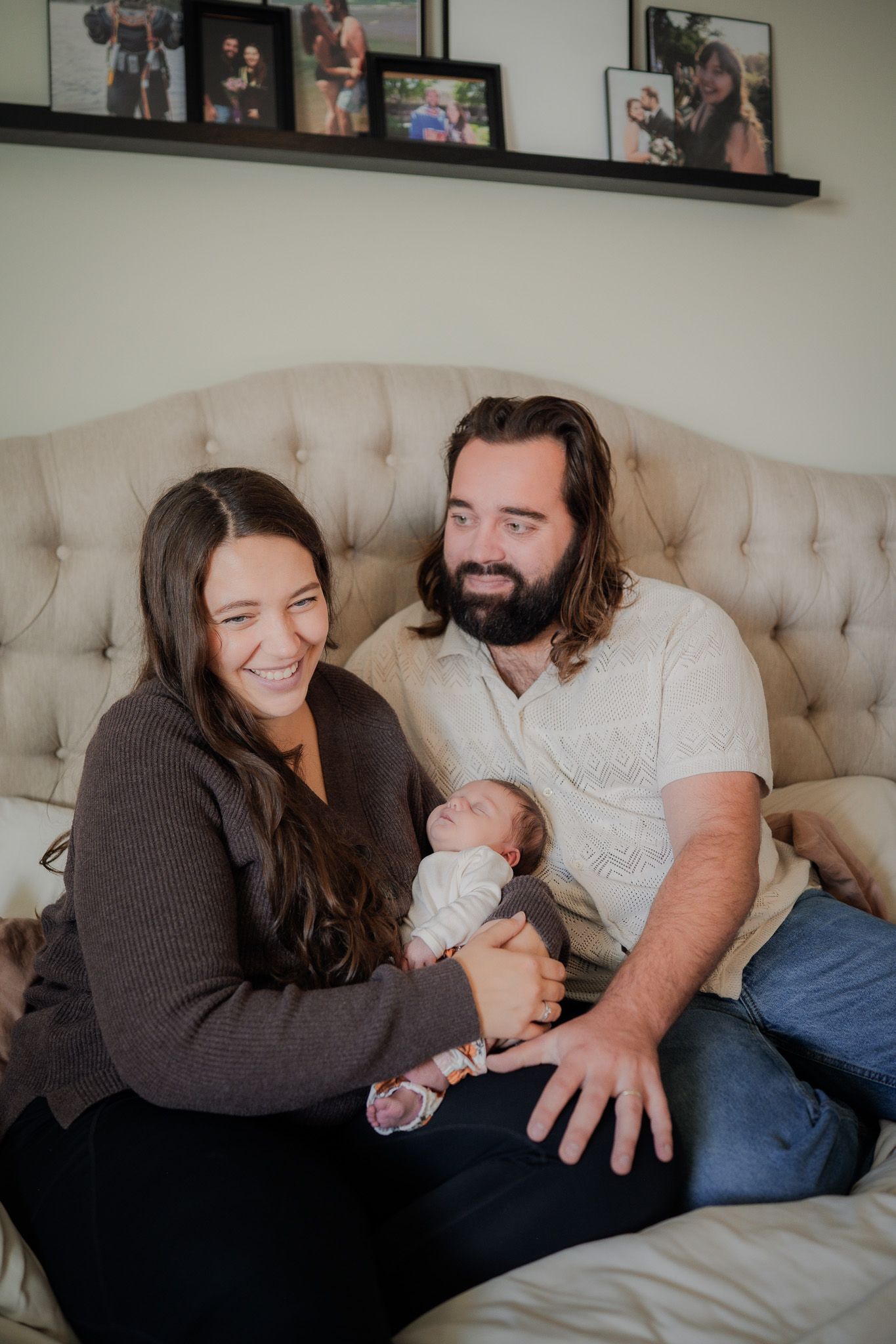 A family shares tender moments together while relaxing on a beige tufted couch at home.