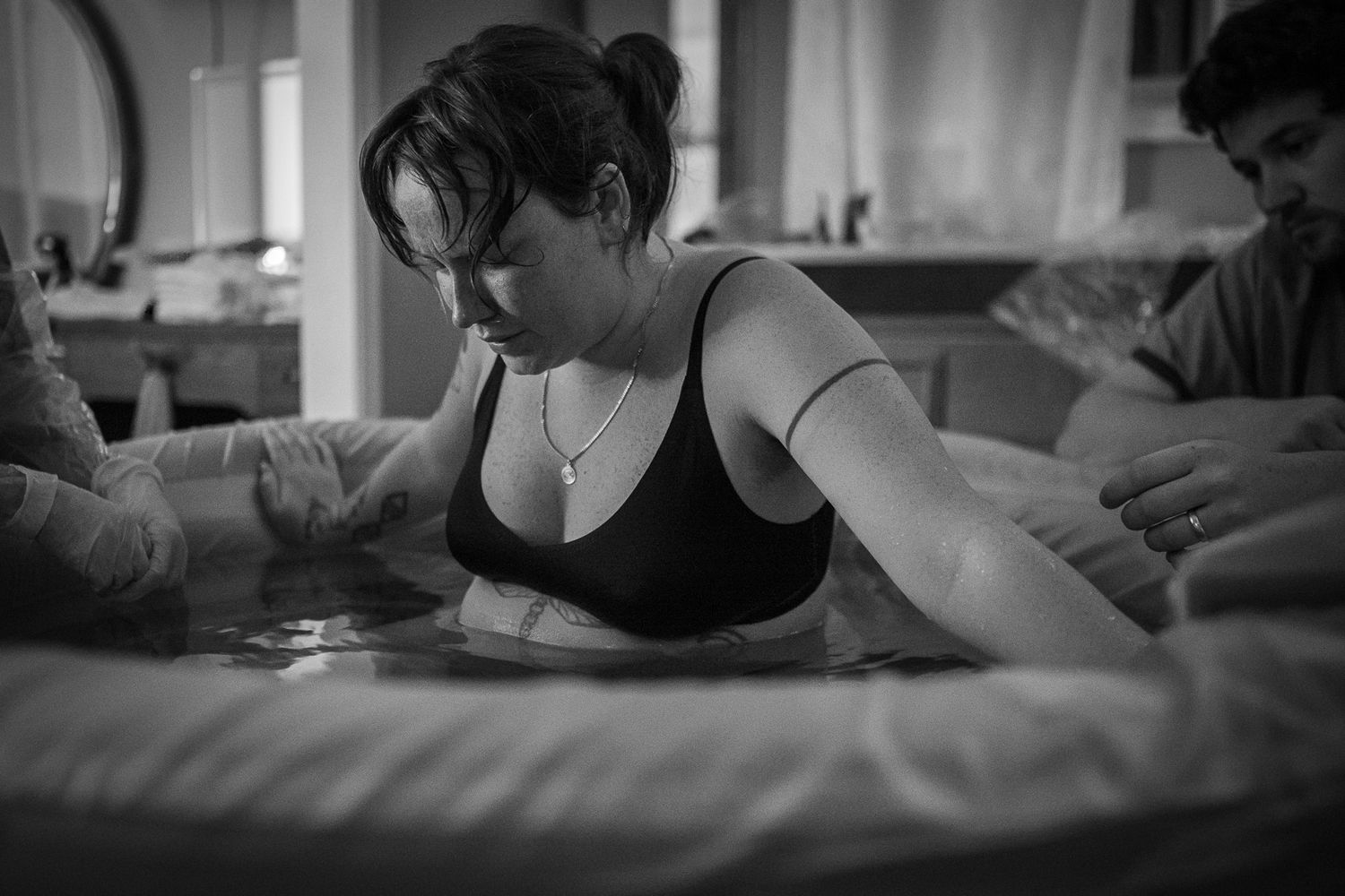 Black and white image showing supportive care during labor. Birth Photographer Ontario