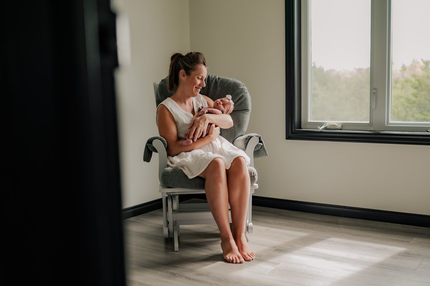 Natural light streams through windows as figures rest in a minimalist room setting.