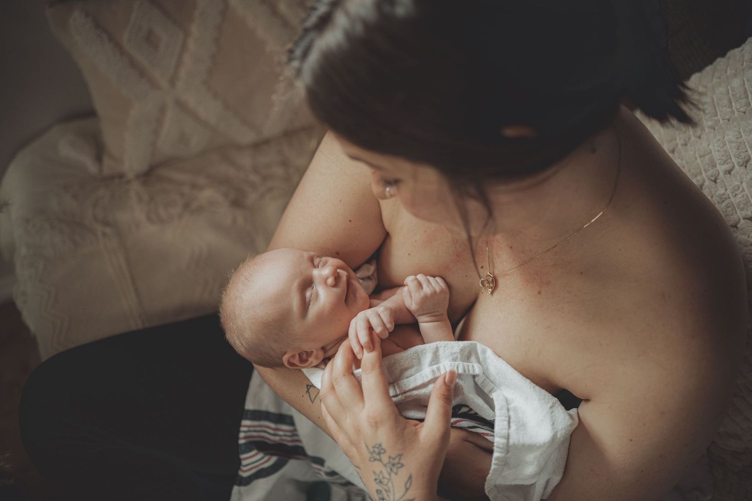 Artistic newborn photography with soft neutral tones and gentle poses.