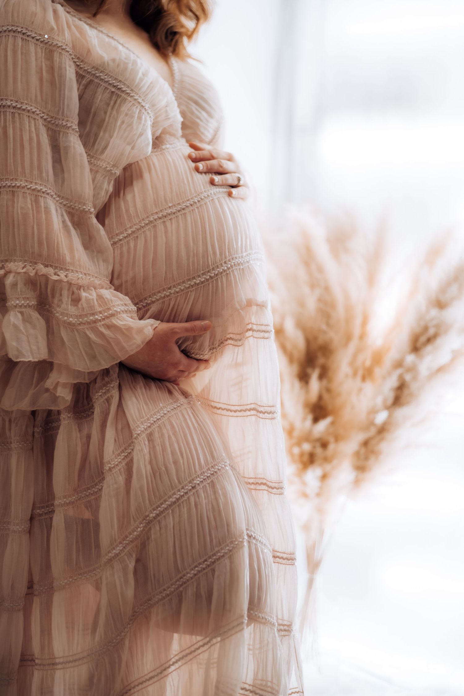 Elegant maternity portrait series in cream colored textured dress against white studio backdrop. Maternity photographer Ontario